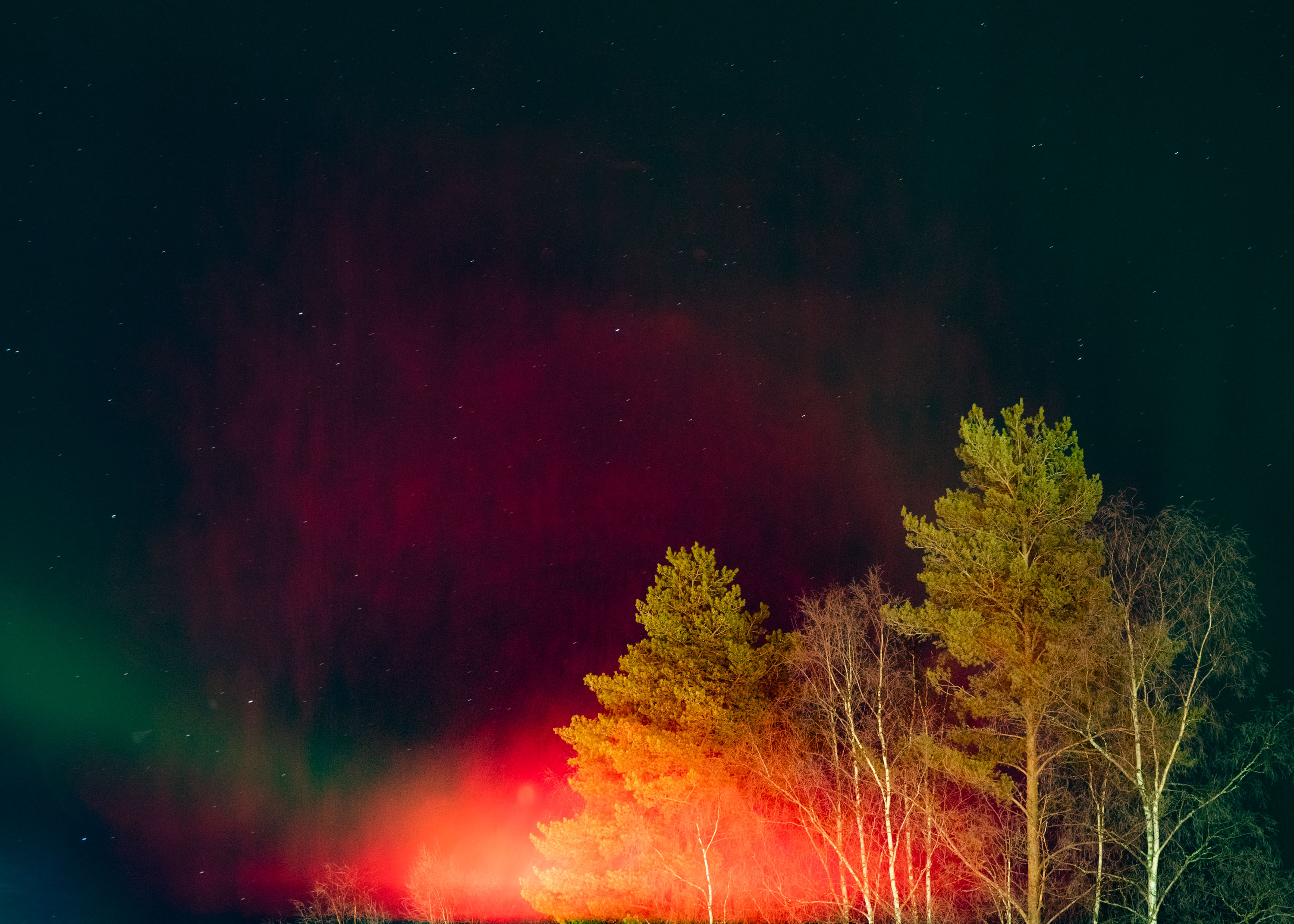 Une image d'aurores boréales avec une lumière ambiante orange et rouge éclatante
