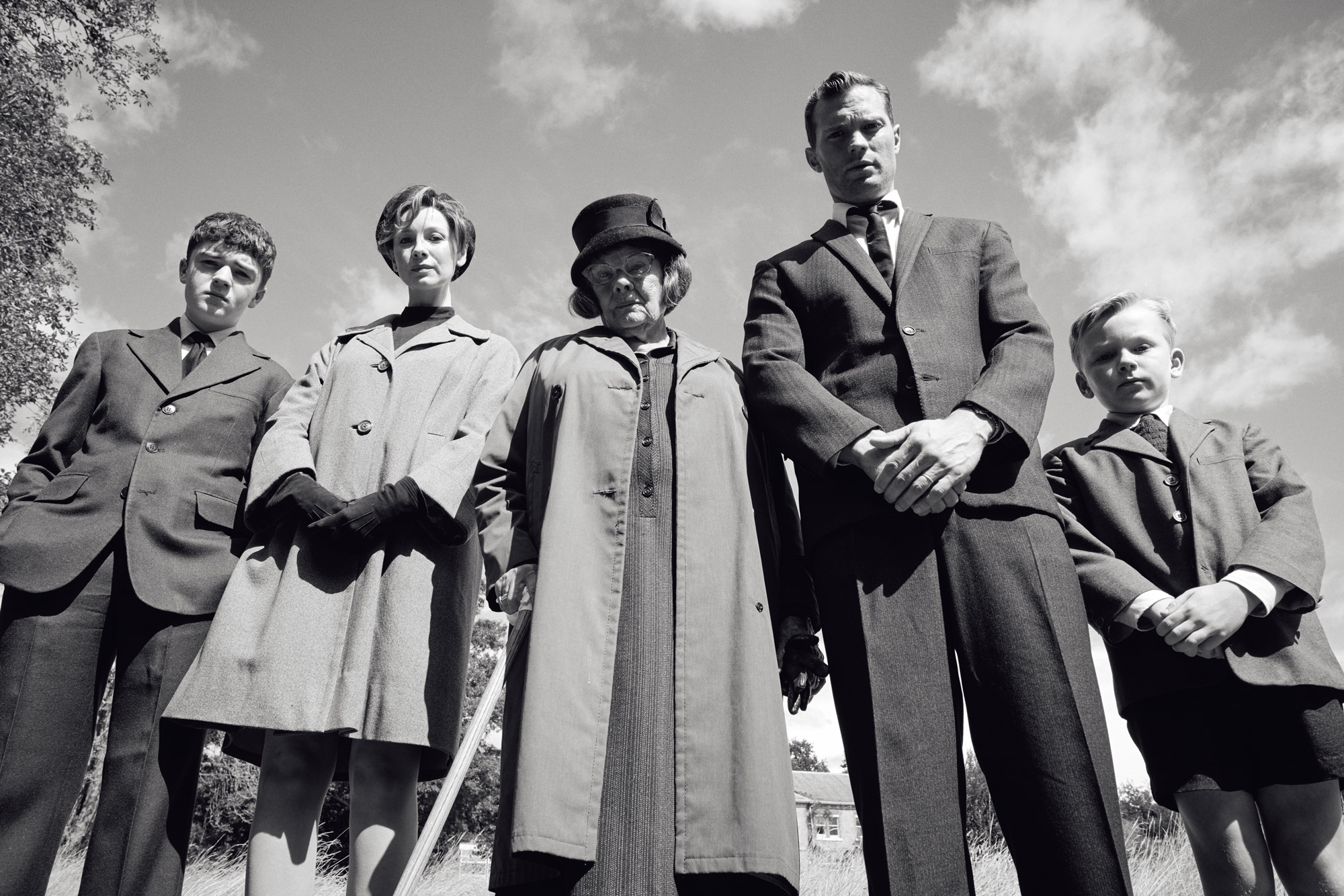 Five people stand looking down.