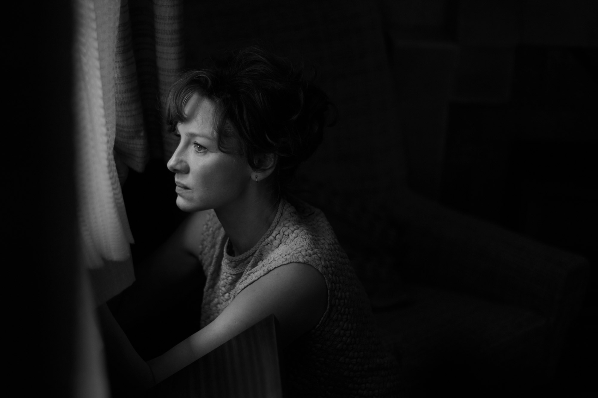 A woman looks out of a window.