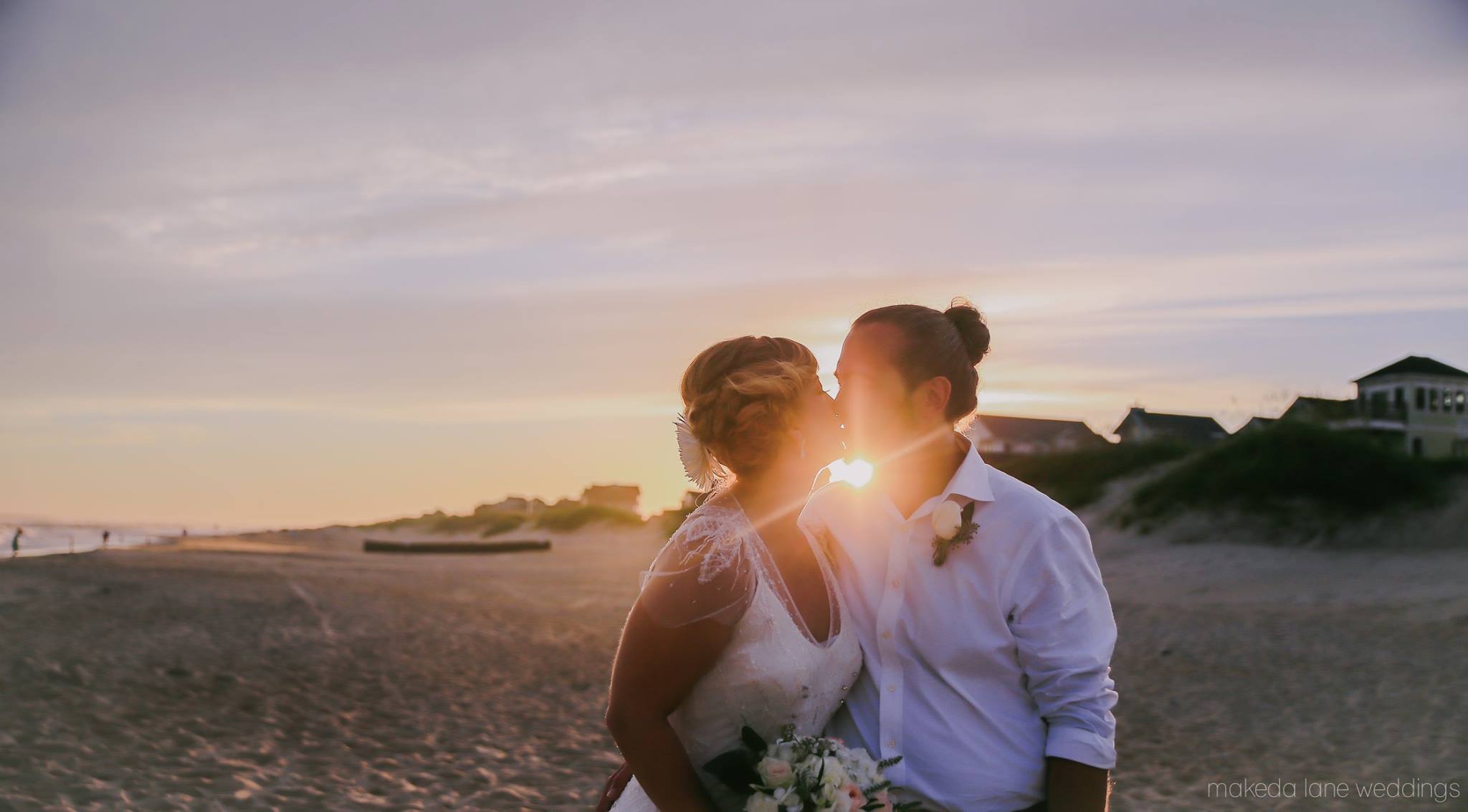 Un couple s'embrasse devant un coucher de soleil