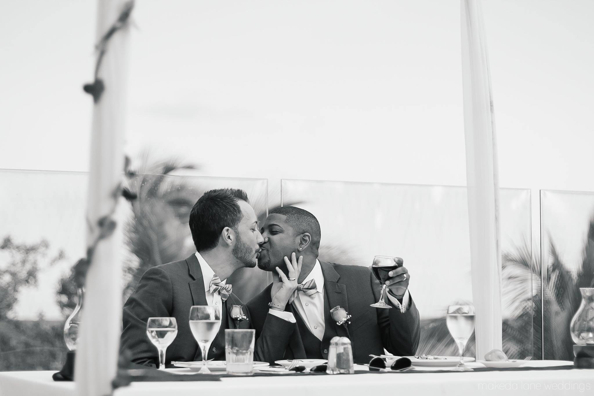 A wedding couple kisses at the reception