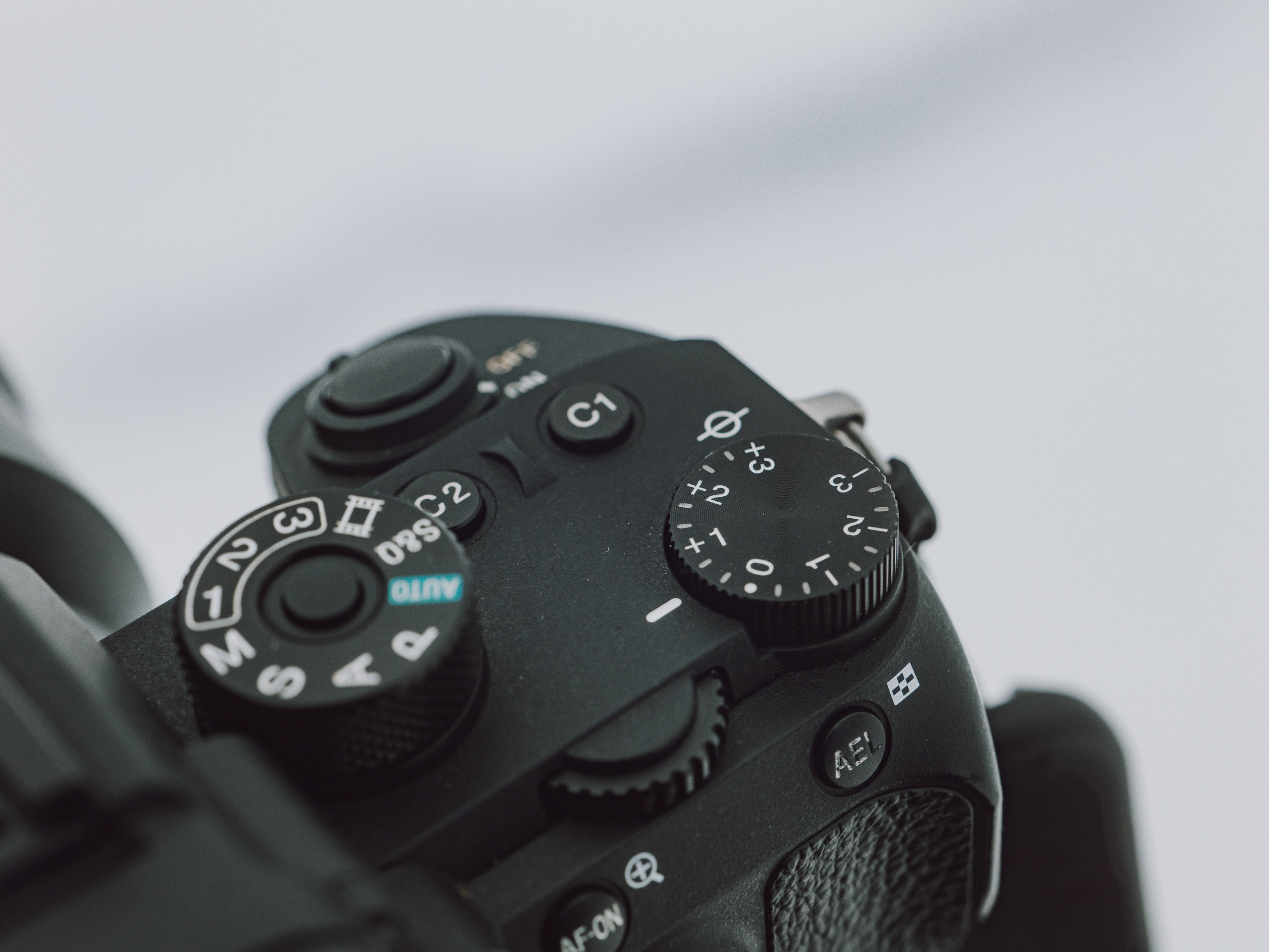 Gros plan sur les cadrans supérieurs d'un Sony A9 avec de la neige en arrière-plan.