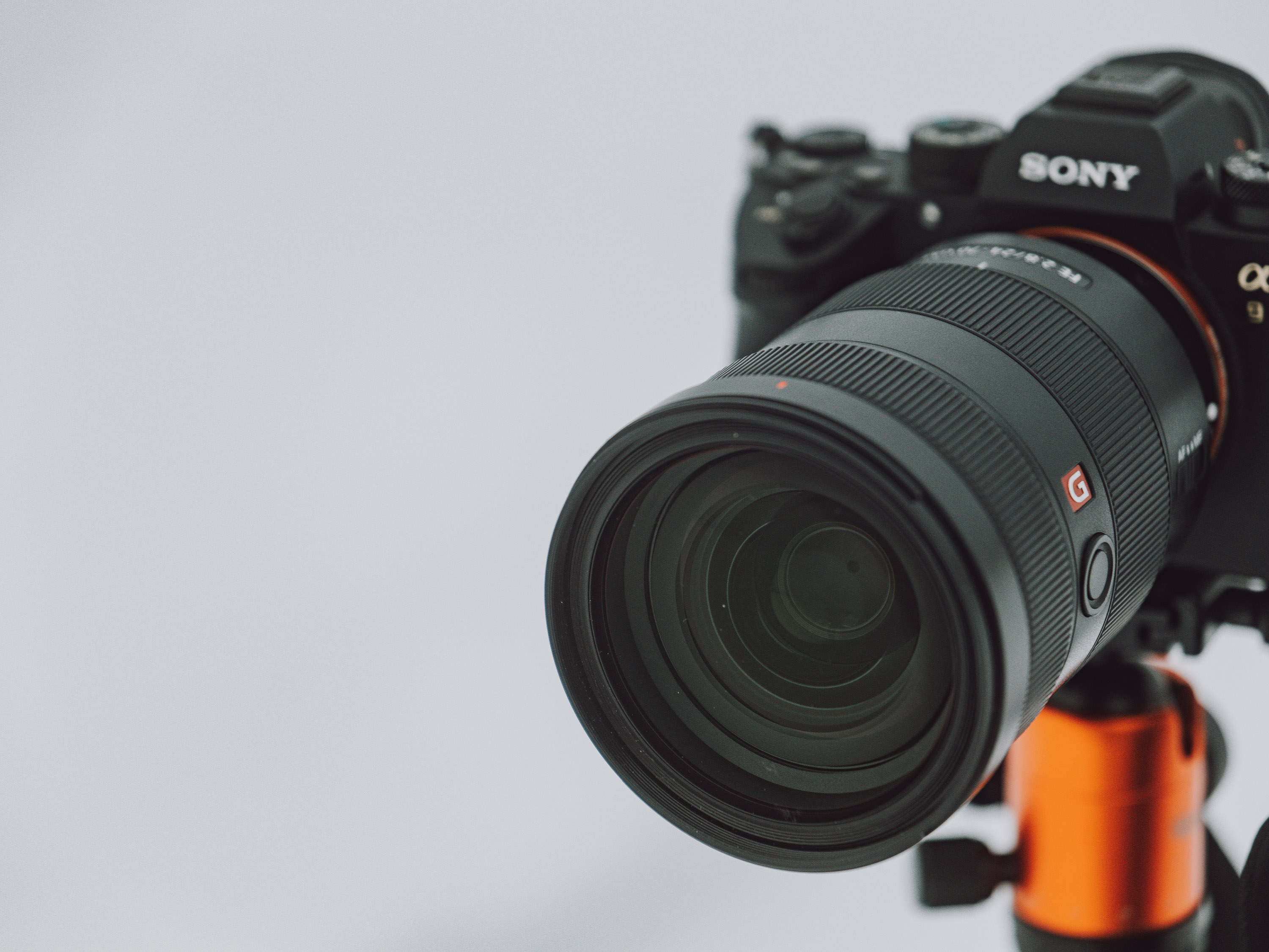 Close up shot of a Sony A9. mounted on a tripod with snow in the background.