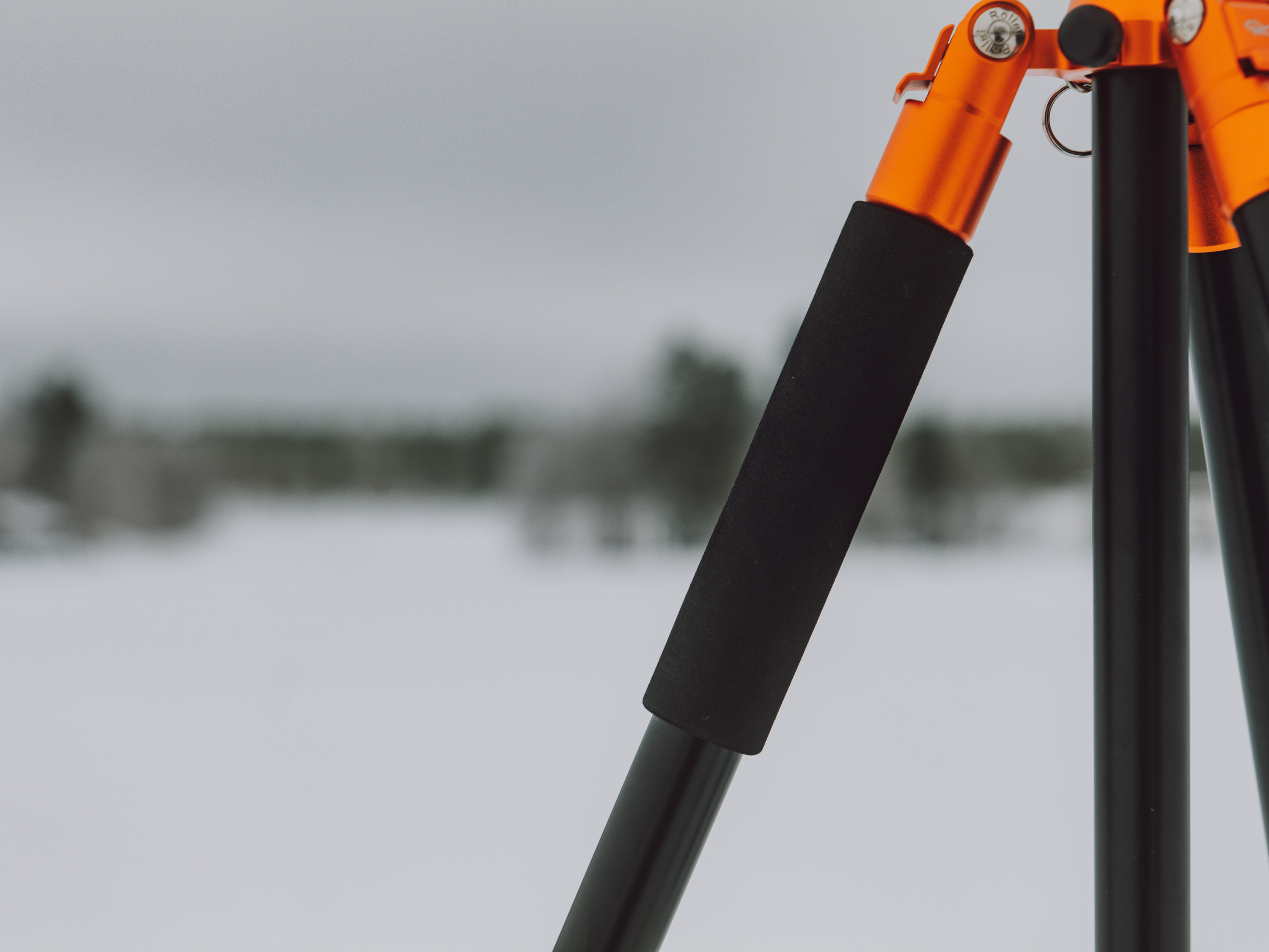 Close up photo of an orange and black tripod on a white background.