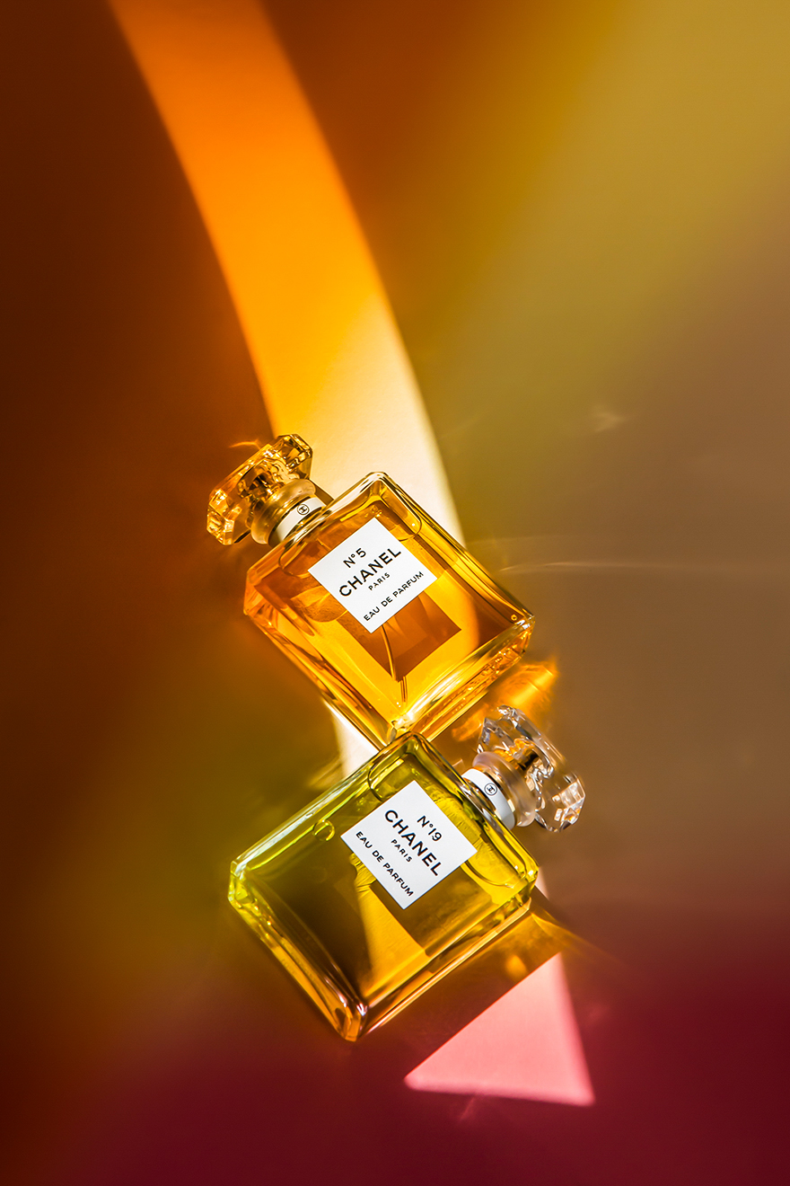 an artificially lit image of two bottles of Chanel perfume with yellow and pink light