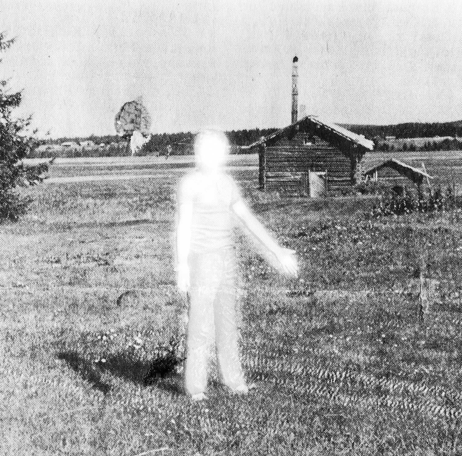 a black and white image of a man in a field that seems to glow with over exposure