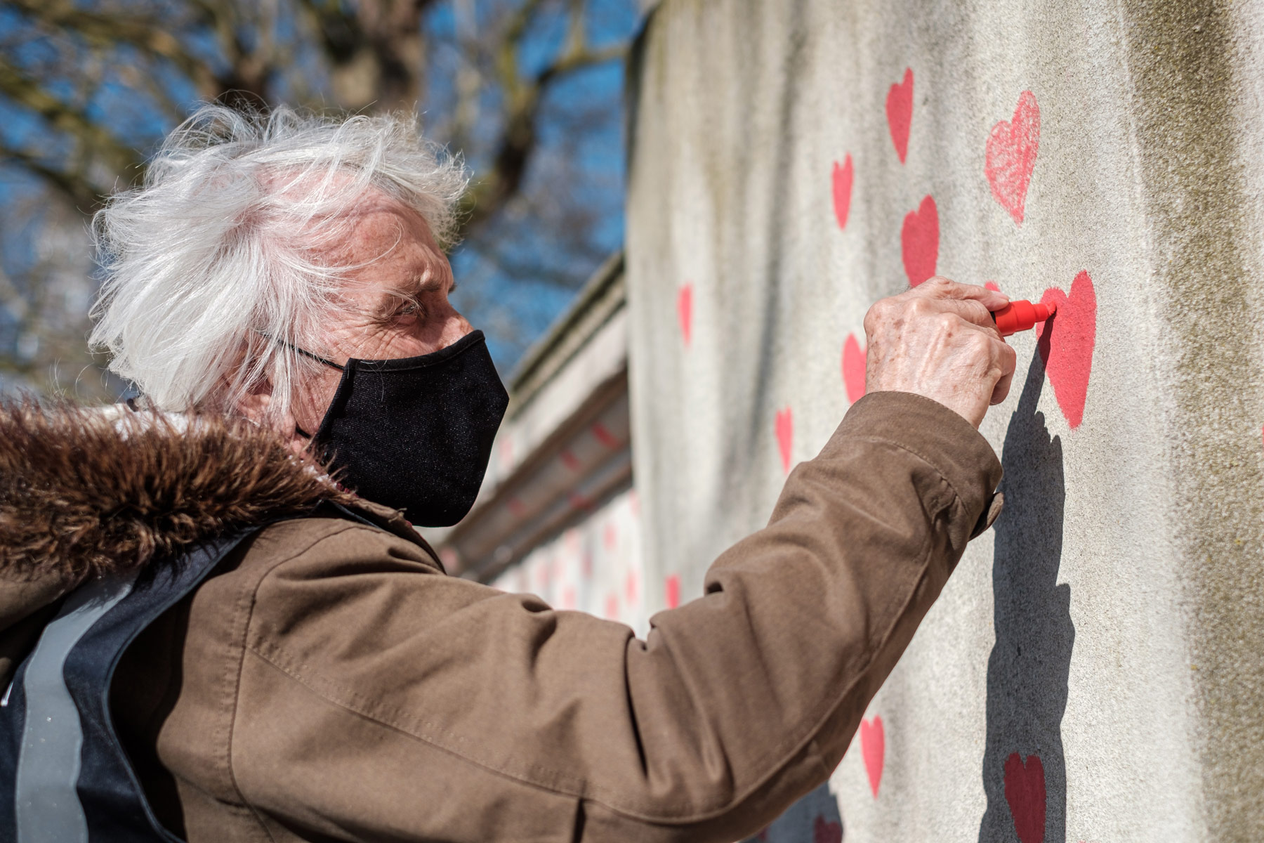 Man participating in Stop Asian Hate protest, drawing heart