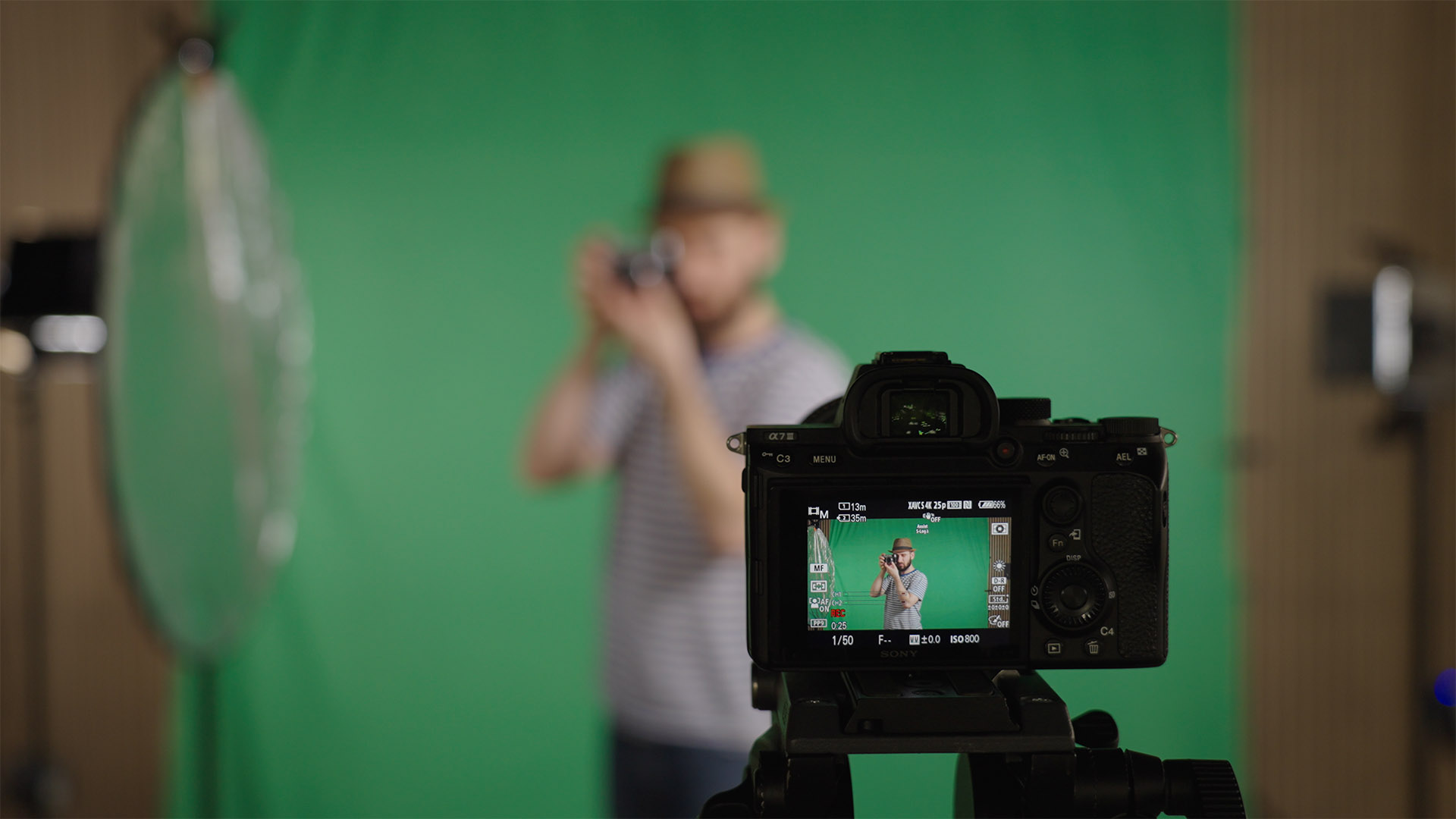 A Sony FX3 mounted to a video tripod with with an Atomos recorder attached, in front of a neon pink MPB logo.