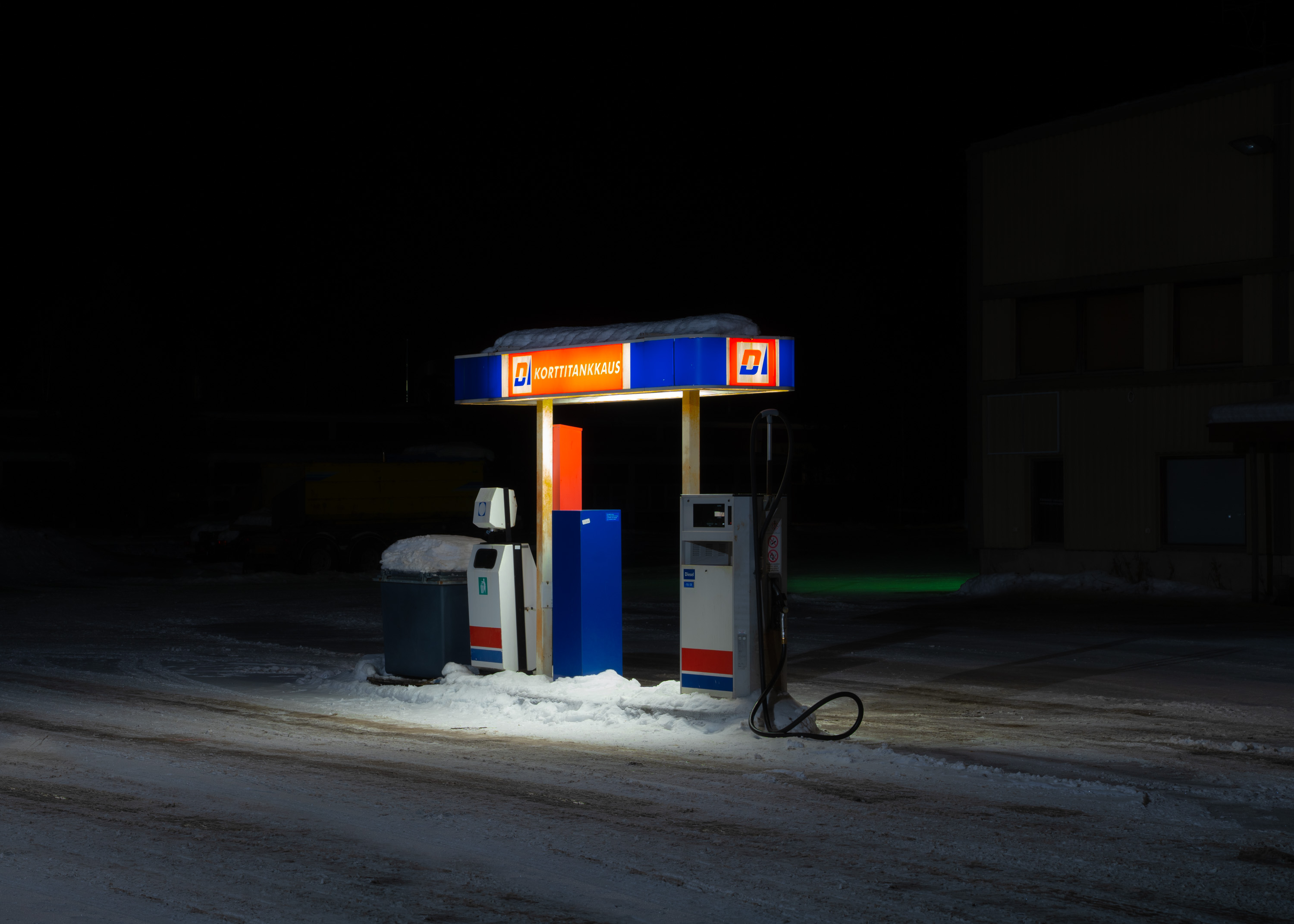 A gas station pump lit up at night.