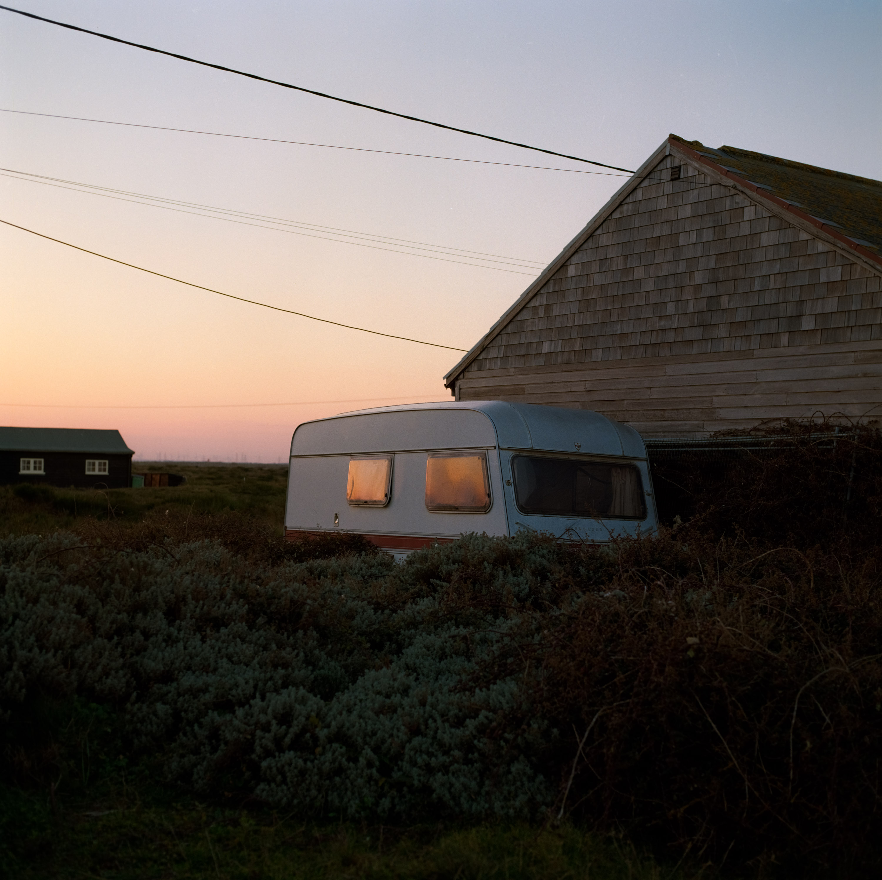 A caravan at dusk besides a house shot on Kodak Gold 200 120mm medium format film