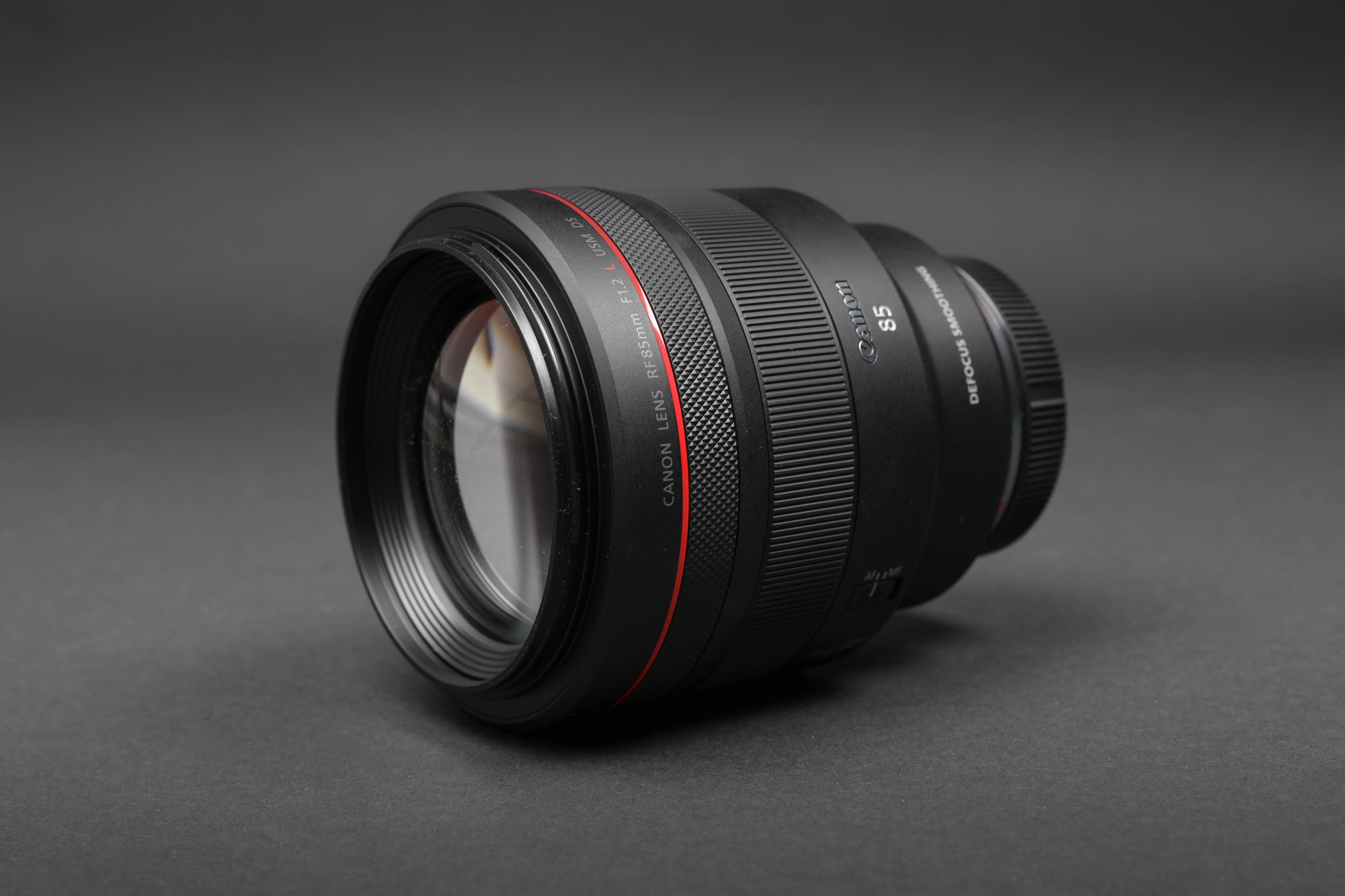 Ein Bild des Canon 85mm f/1.2 vor einem dunkelgrauen Hintergrund CAPTION: Canon 85mm f/1.2