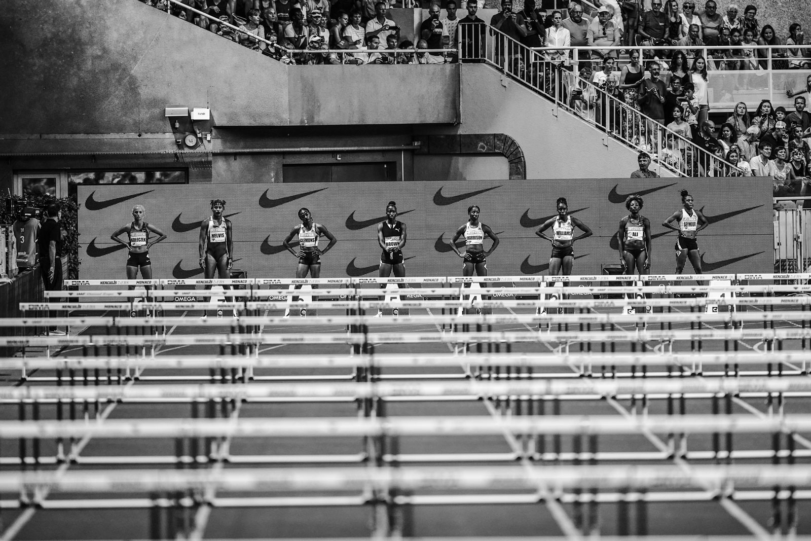 Zwart-witfoto van hordelopers met Nike-teken achter hen