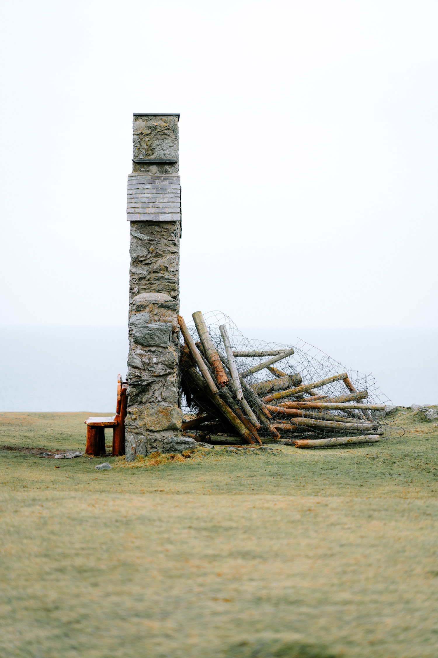 an image of a wall, with broken bits of wood on one side, and a bench on the other.