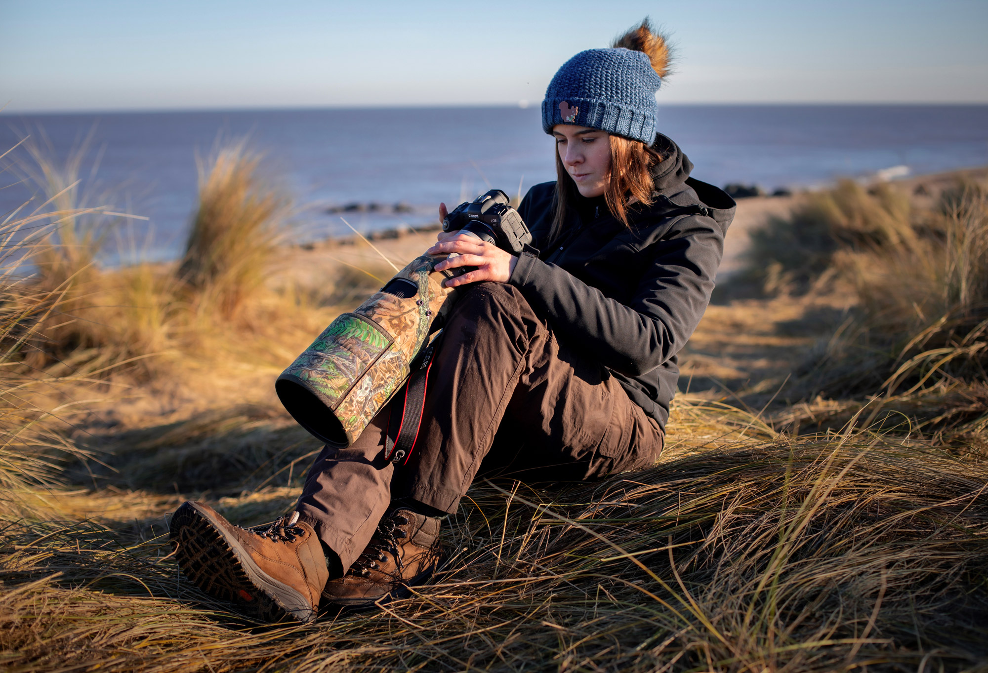 Dani Connor hold a camera on a beach