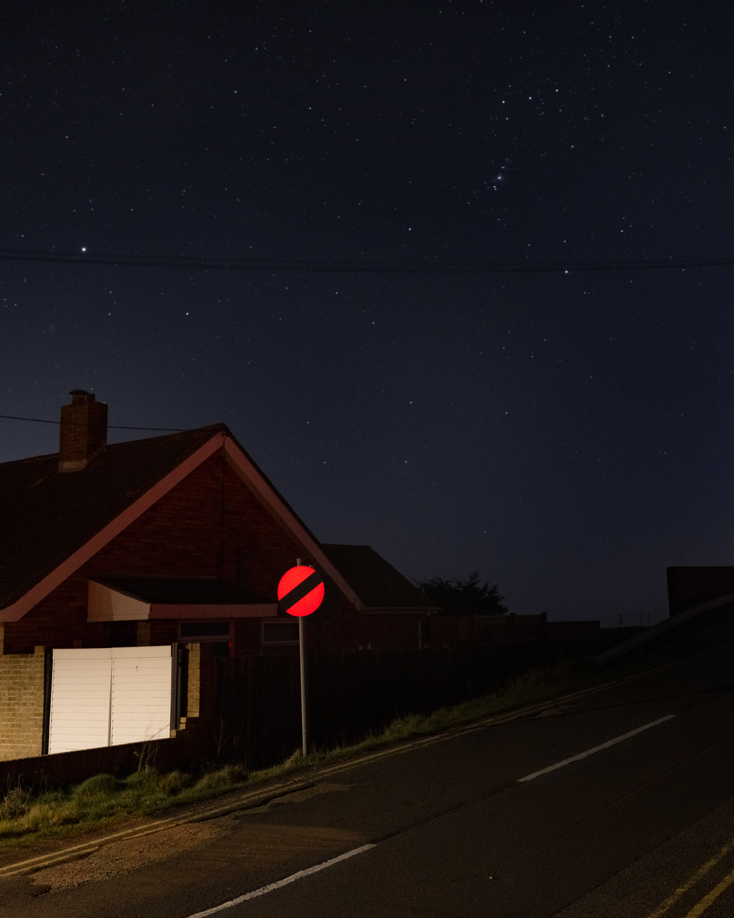 Een stedelijk landschap met een verkeersbord verlicht door een autolamp