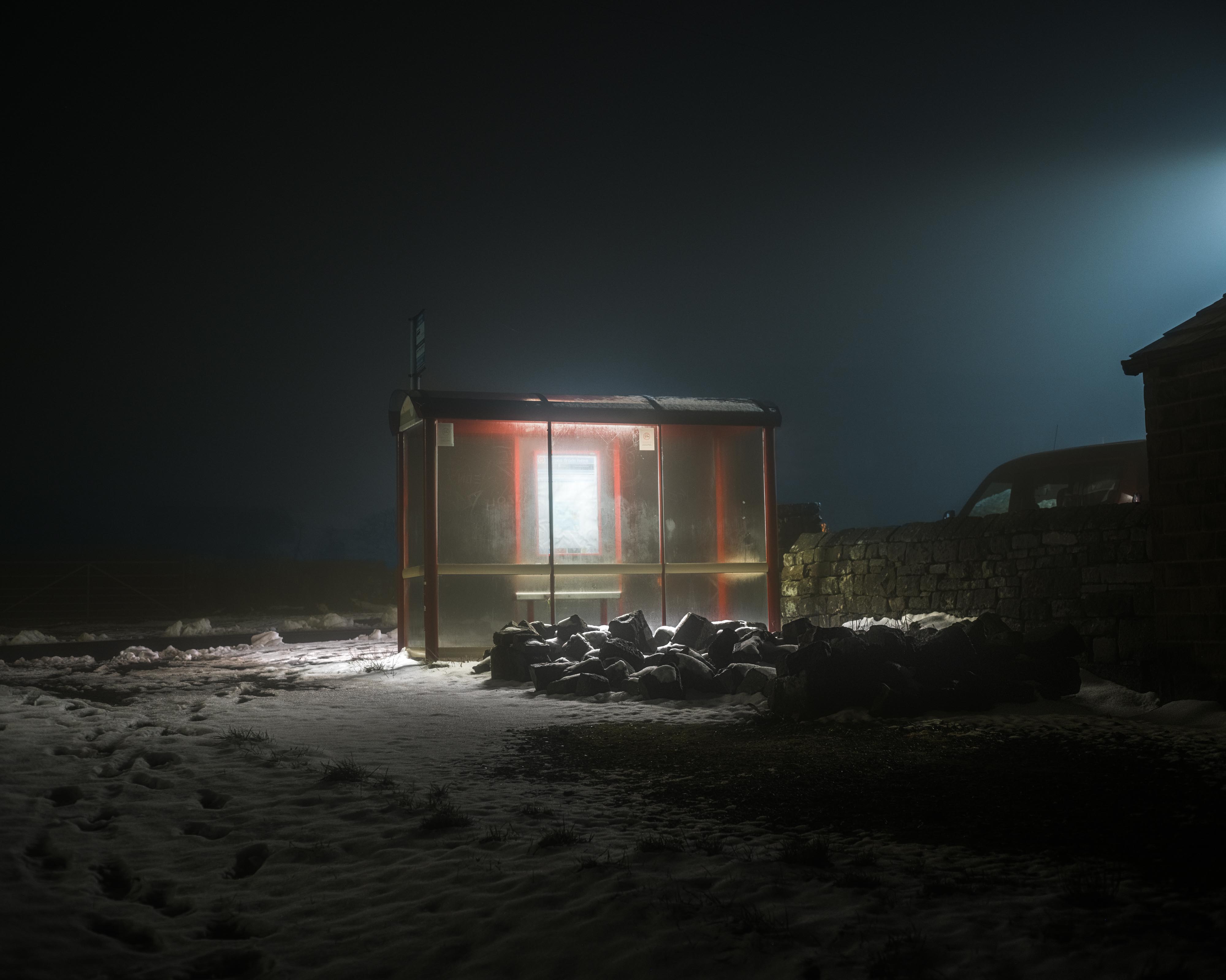a busstop illuminated at night