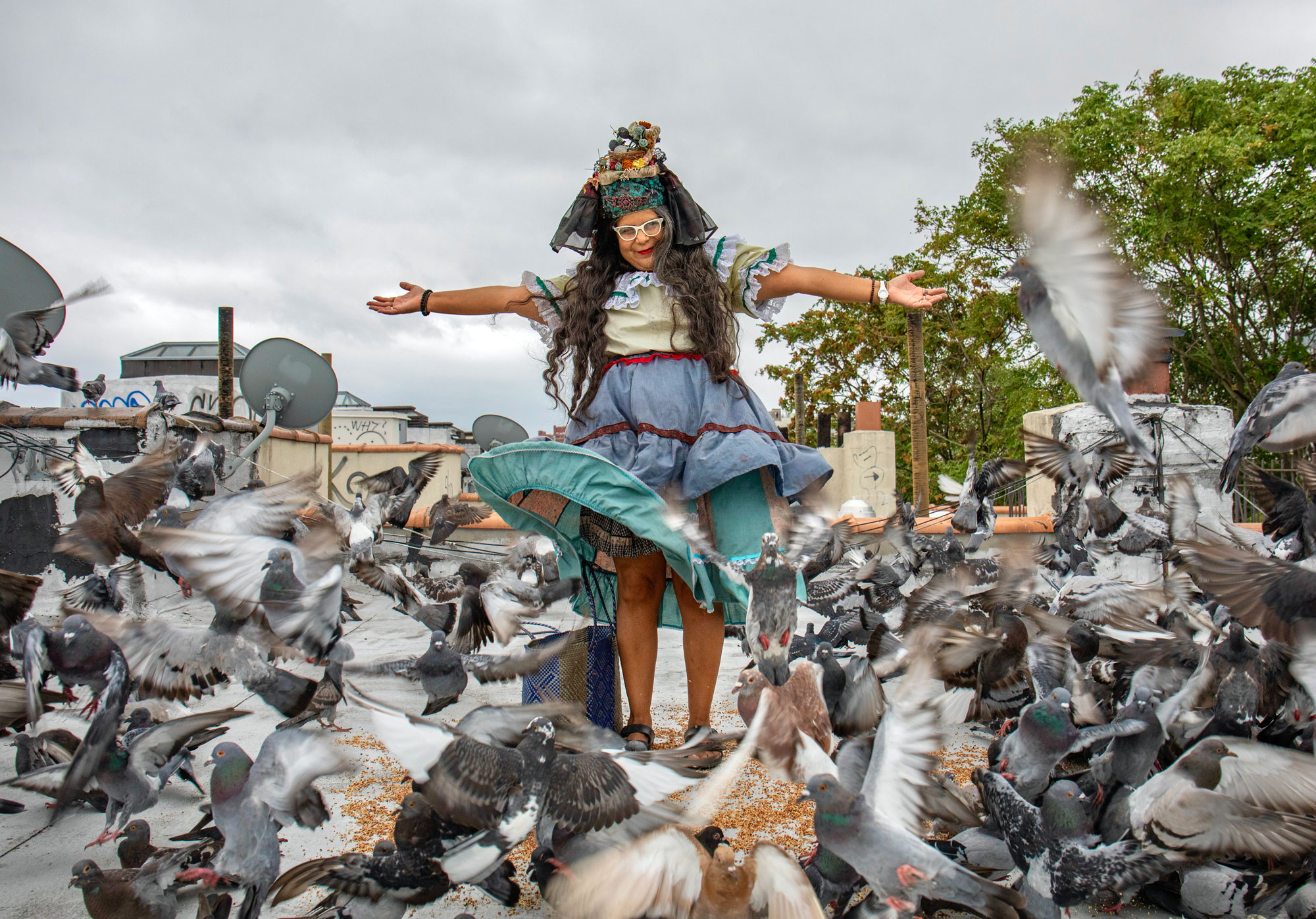 Woman in eccentric clothing and pigeons on New York rooftop