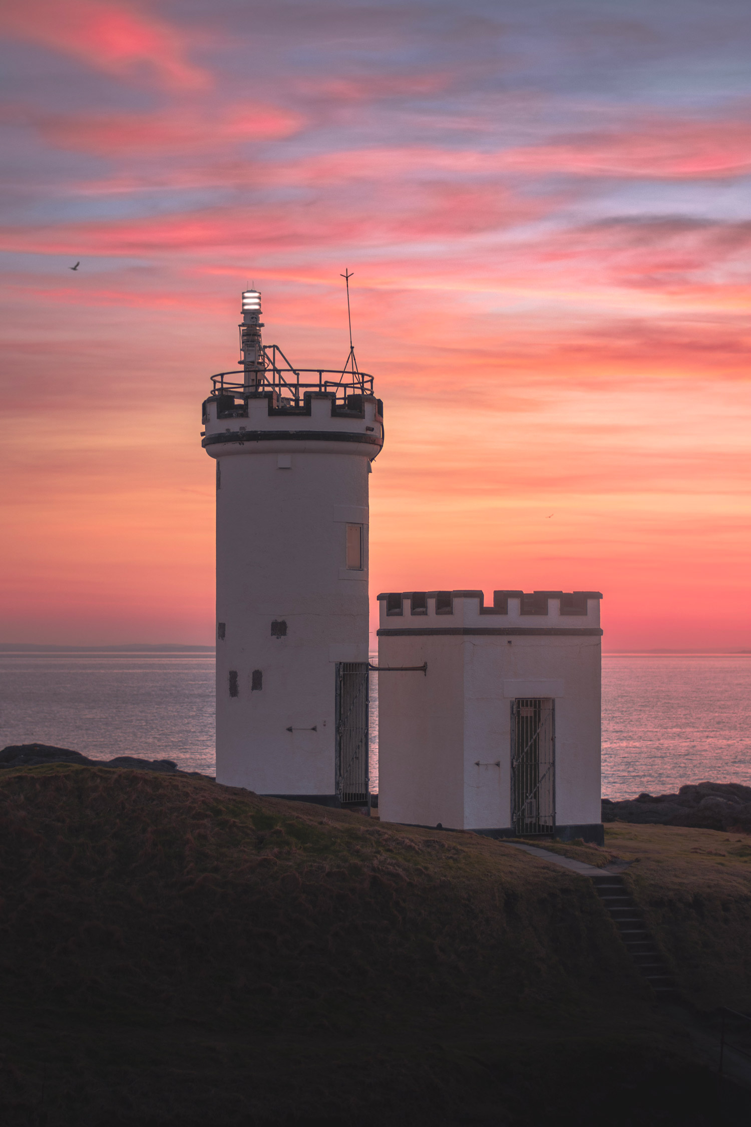 A lighthouse on top of a hill with the sea in the background, shot with the Nikon D7200 and 50mm lens.