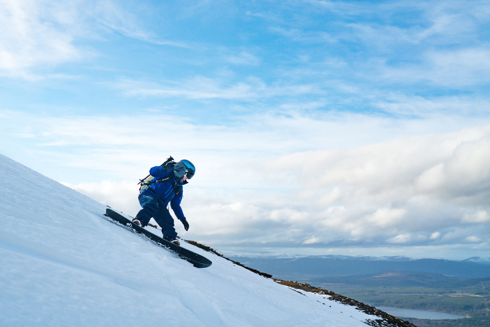Photo of a snowboarder riding in the sun. 