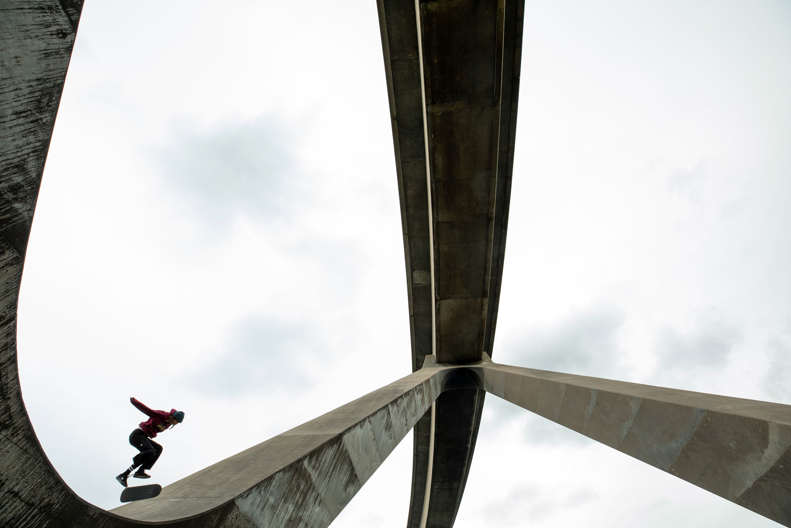 Skateboarder Helena Long skate van een grote betonnen brug af