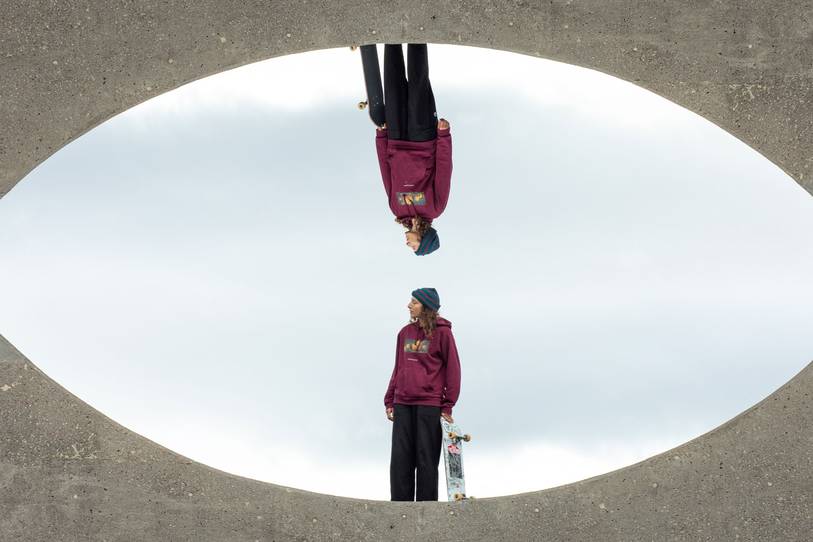 Foto van een skateboarder in een rode trui weerspiegeld boven- en onderaan.