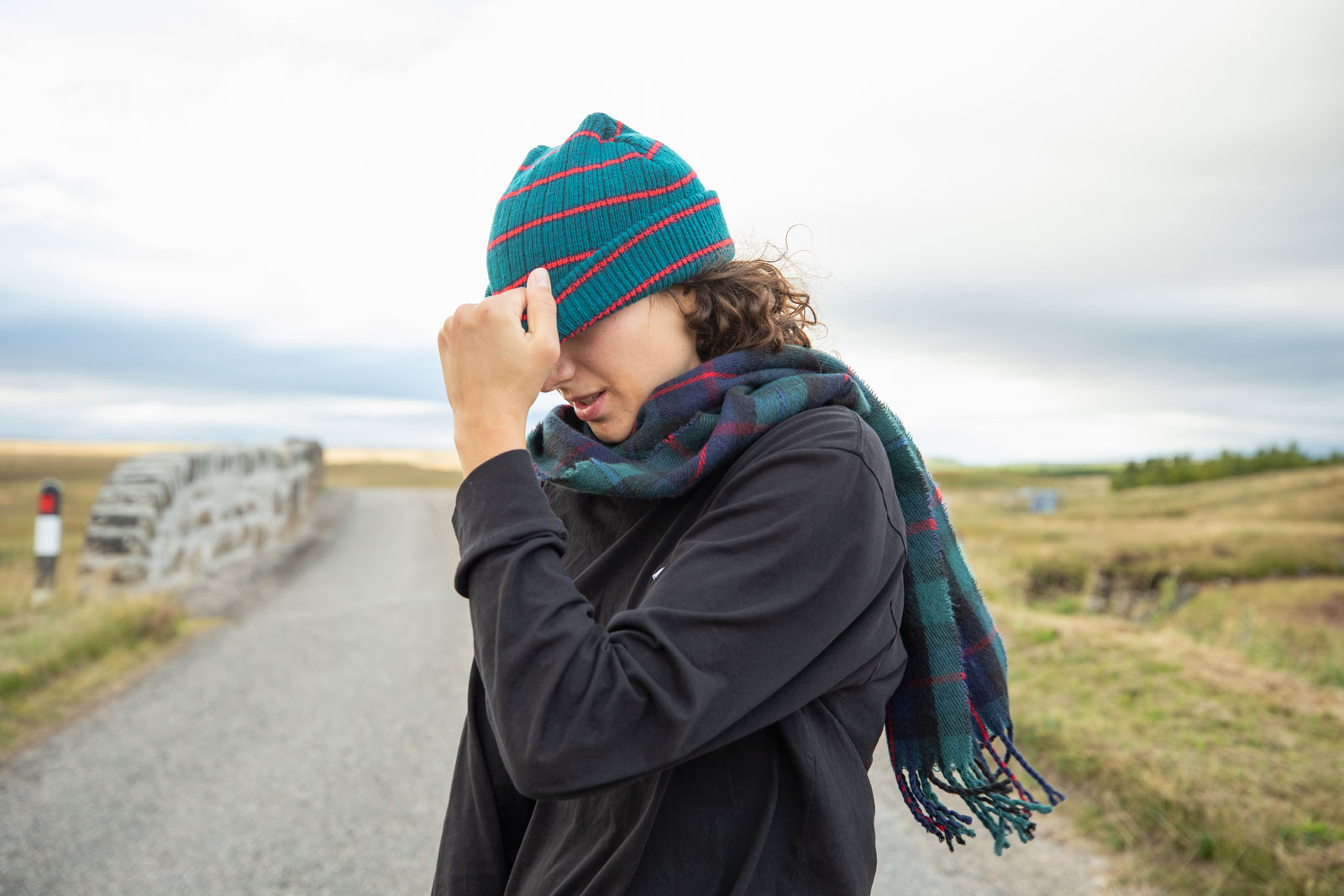 Person with a green and red beanie pulled down over their eyes