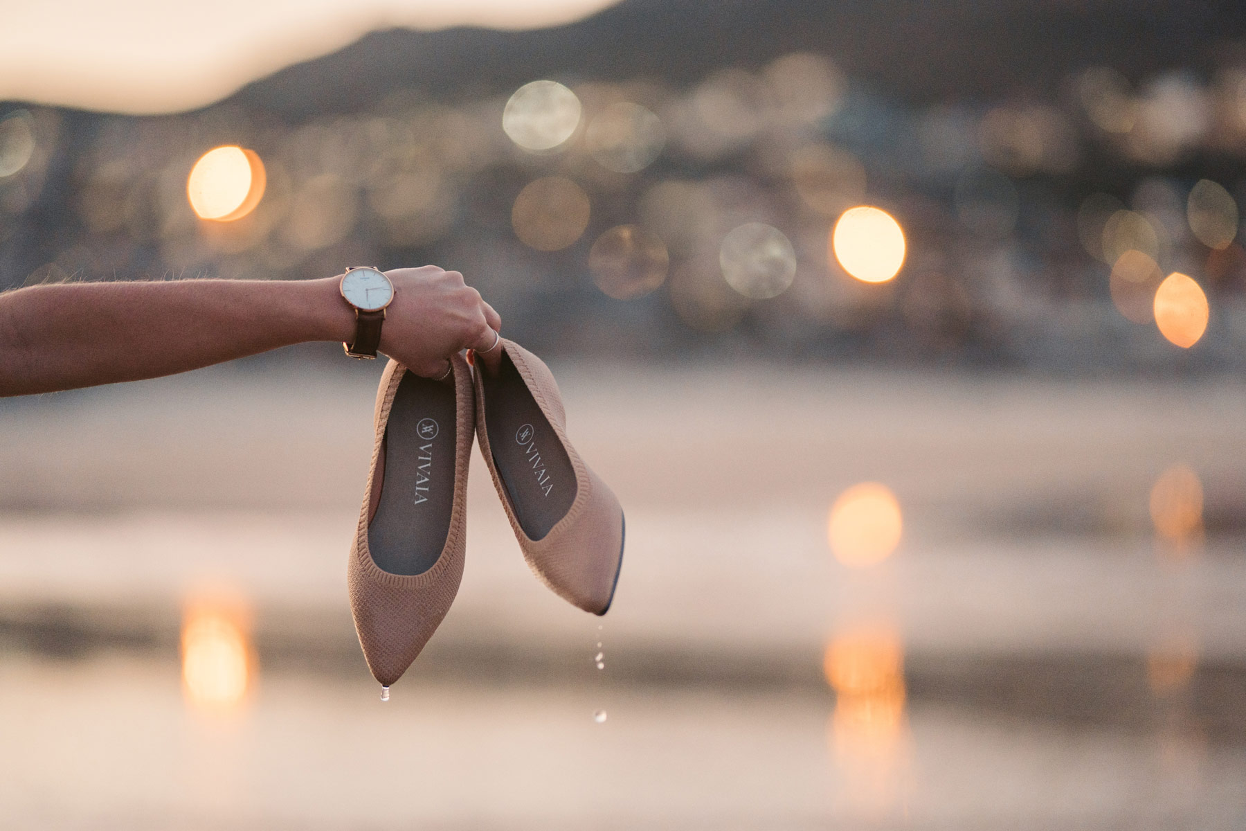 Wet shoes against a beautiful city