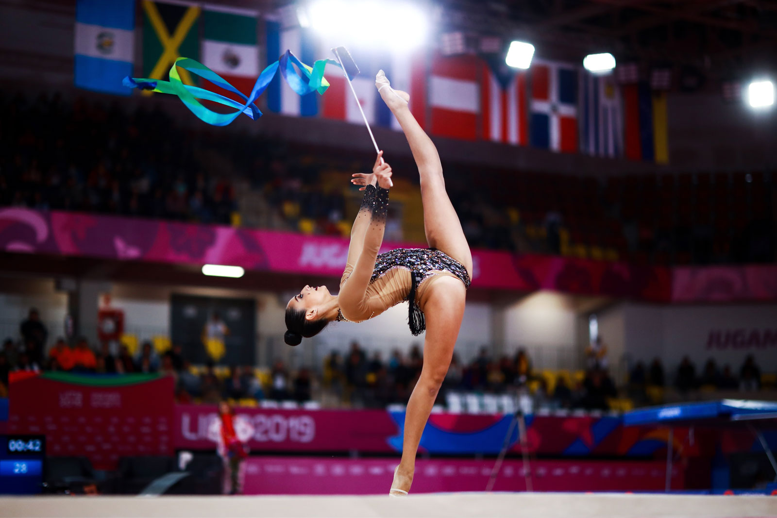 Foto van een gymnastische lintdanseres in een stadion.