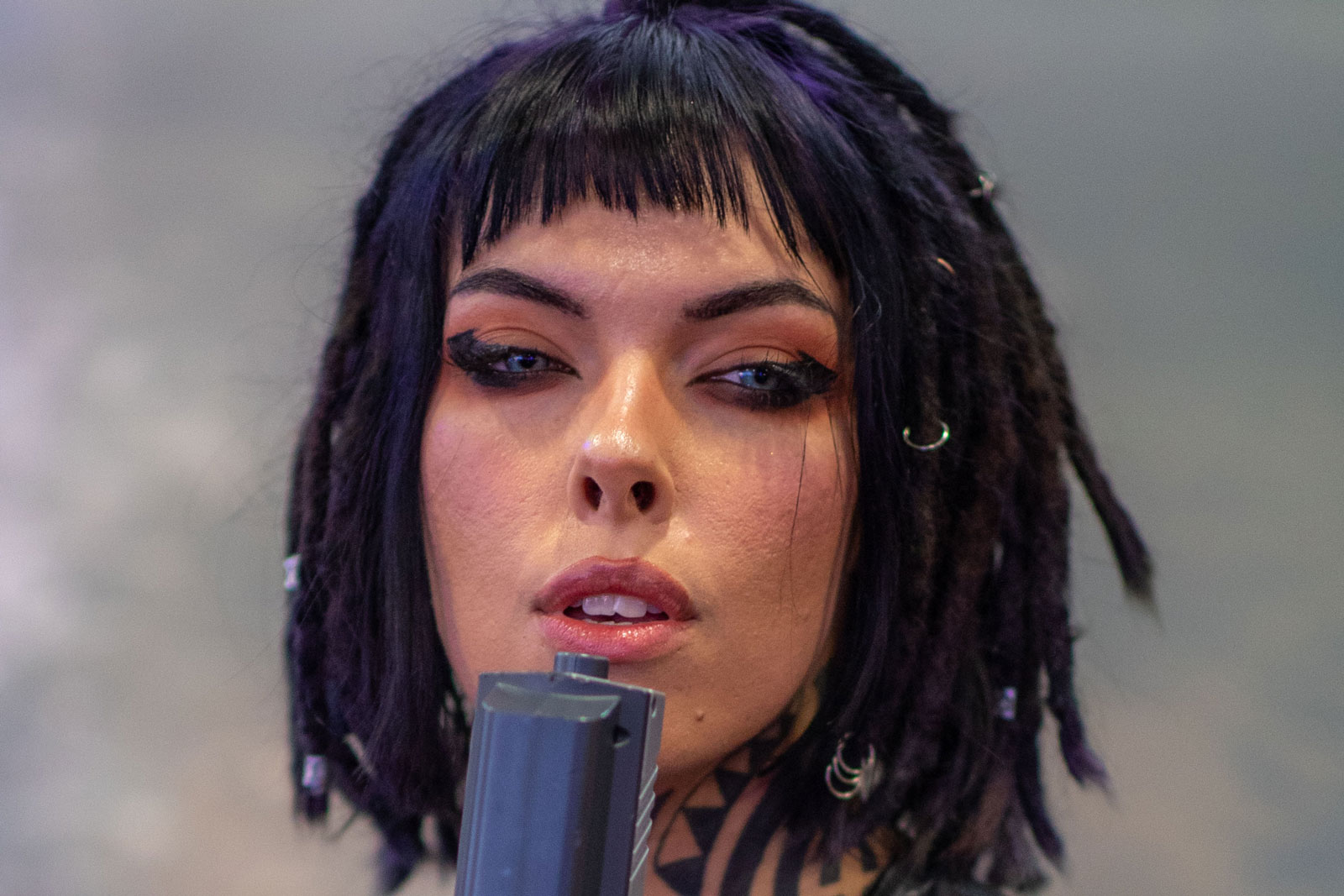 A 100% crop to demonstrate sharpness of the Canon 85mm f/1.4 L IS. Model with dark hair wearing leather holding an arcade gun. Image created with Canon EOS 5D Mark IV + Canon 85mm f/1.4 L IS