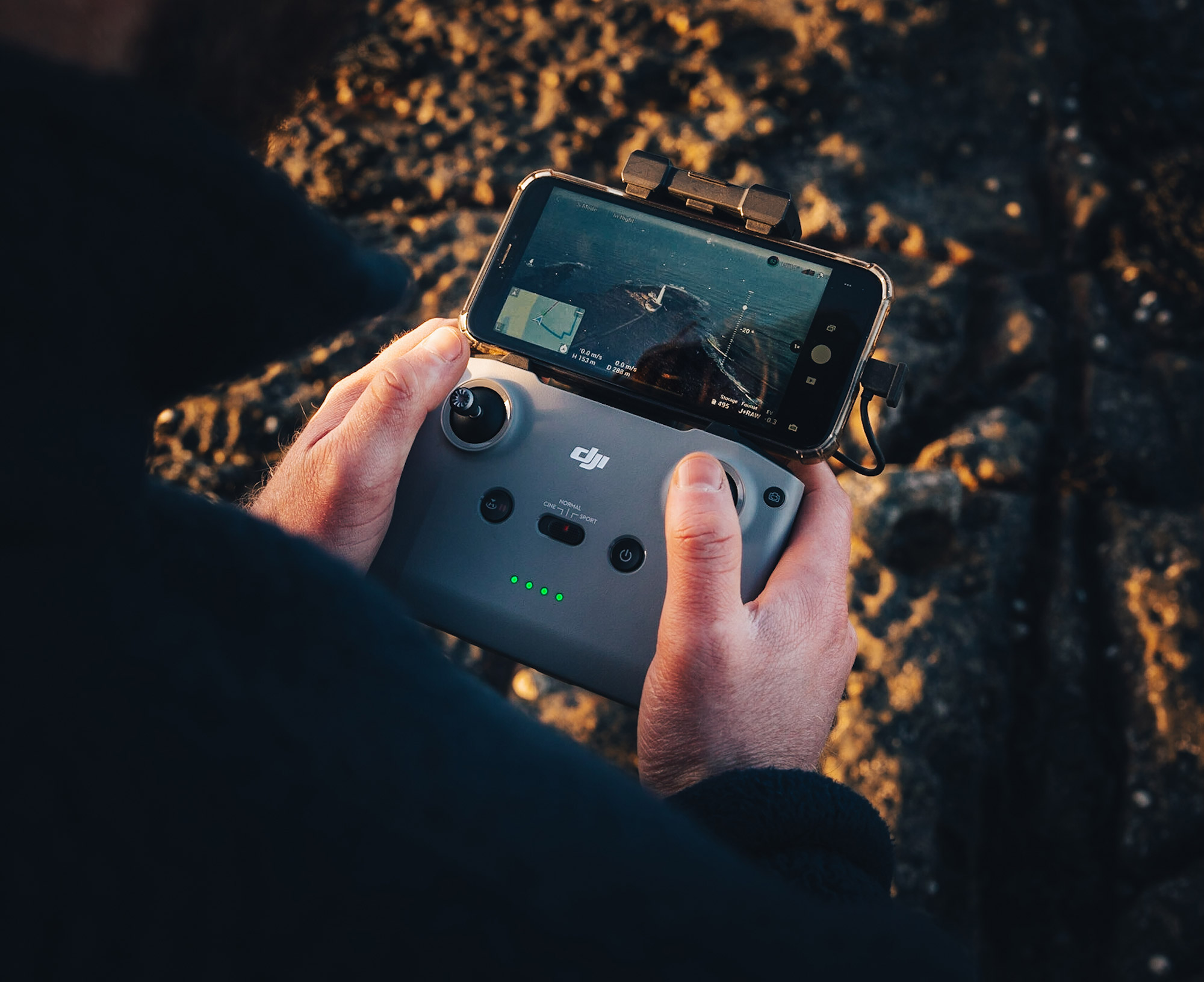 Adam Parkinson tient une commande de drone avec l'image d'un phare à l'écran.