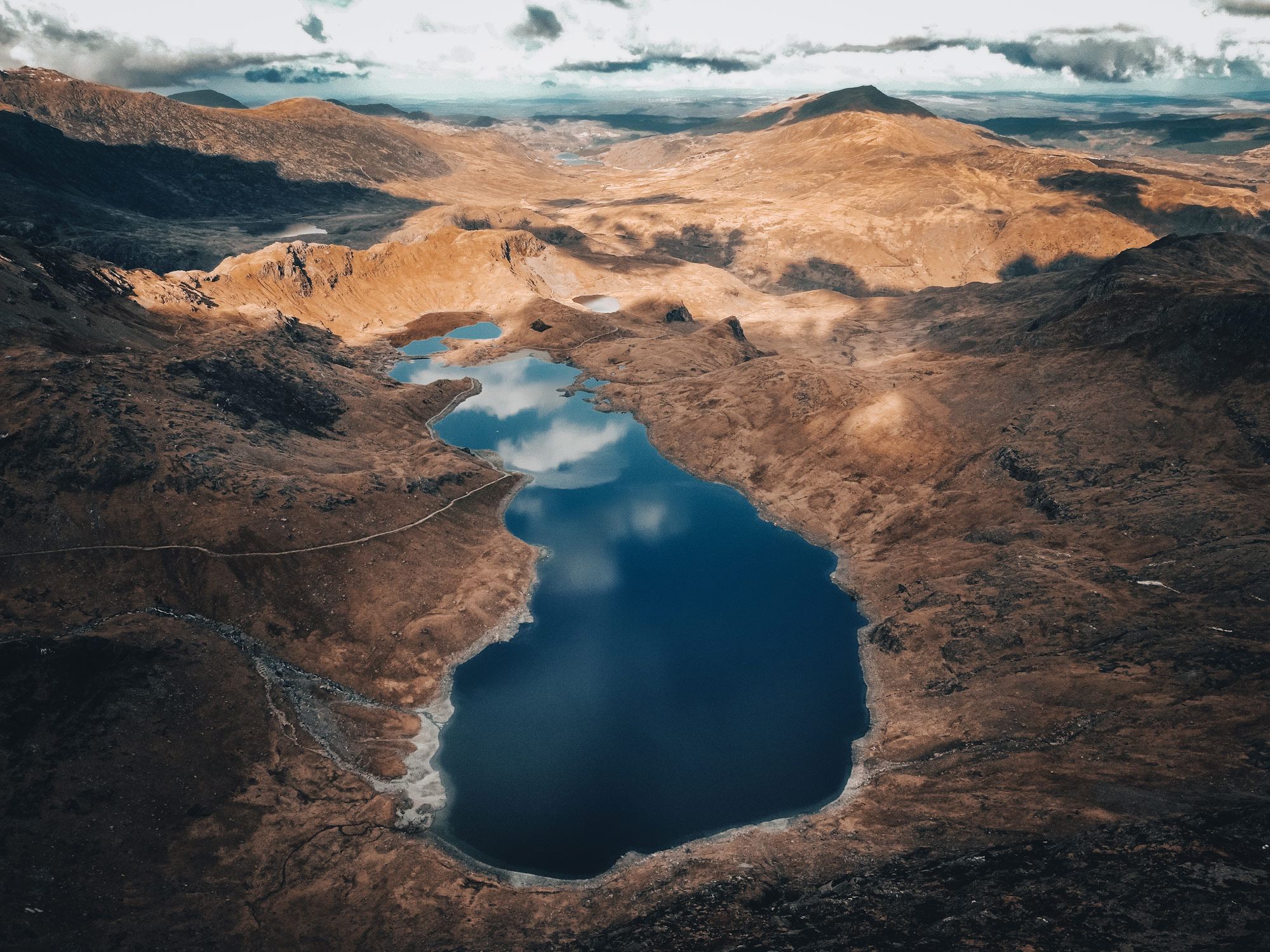 Une chaîne de montagnes avec un lac au fond.