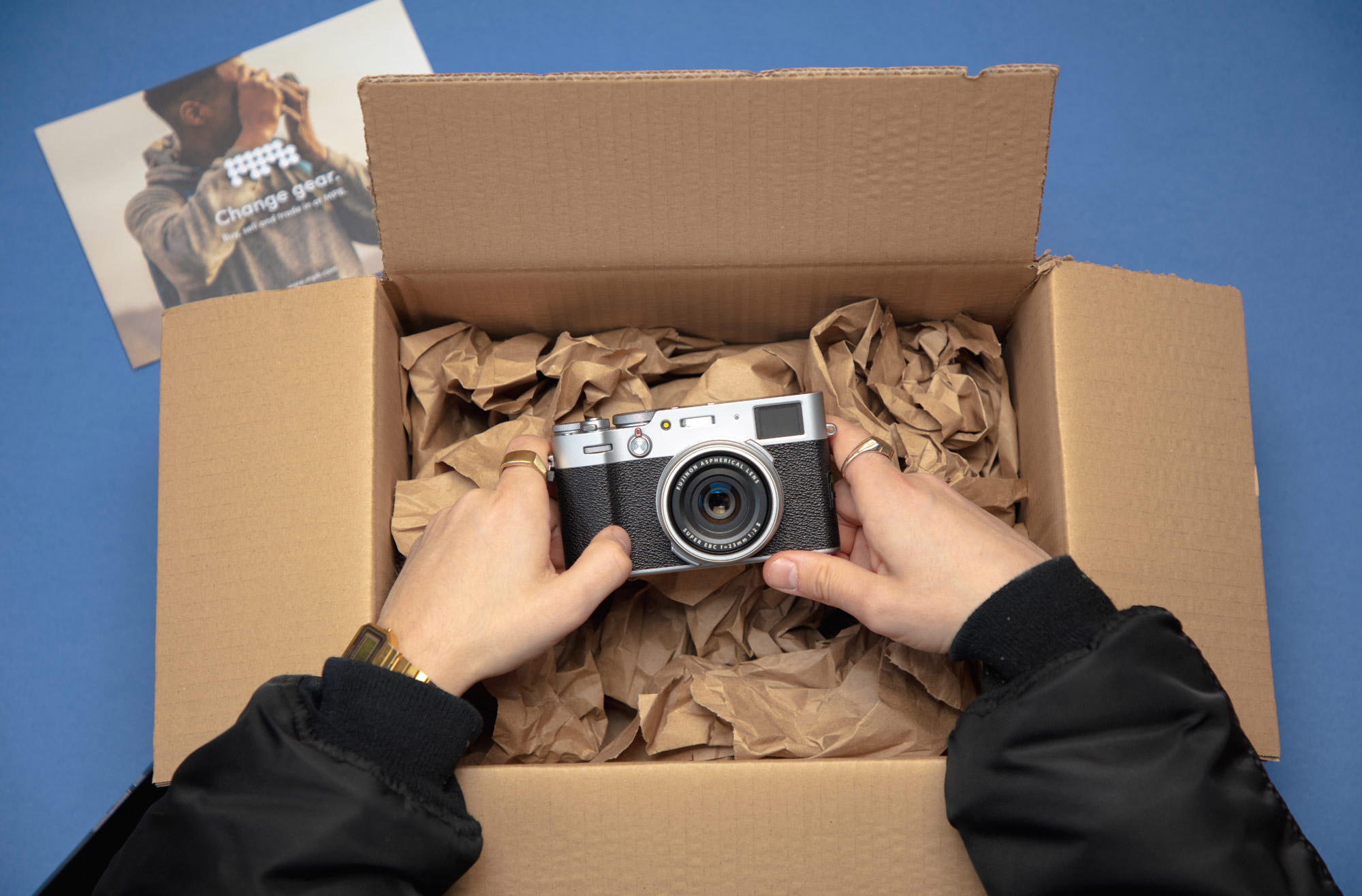 Eine Hand nimmt eine Kamera aus einer Verpackung.