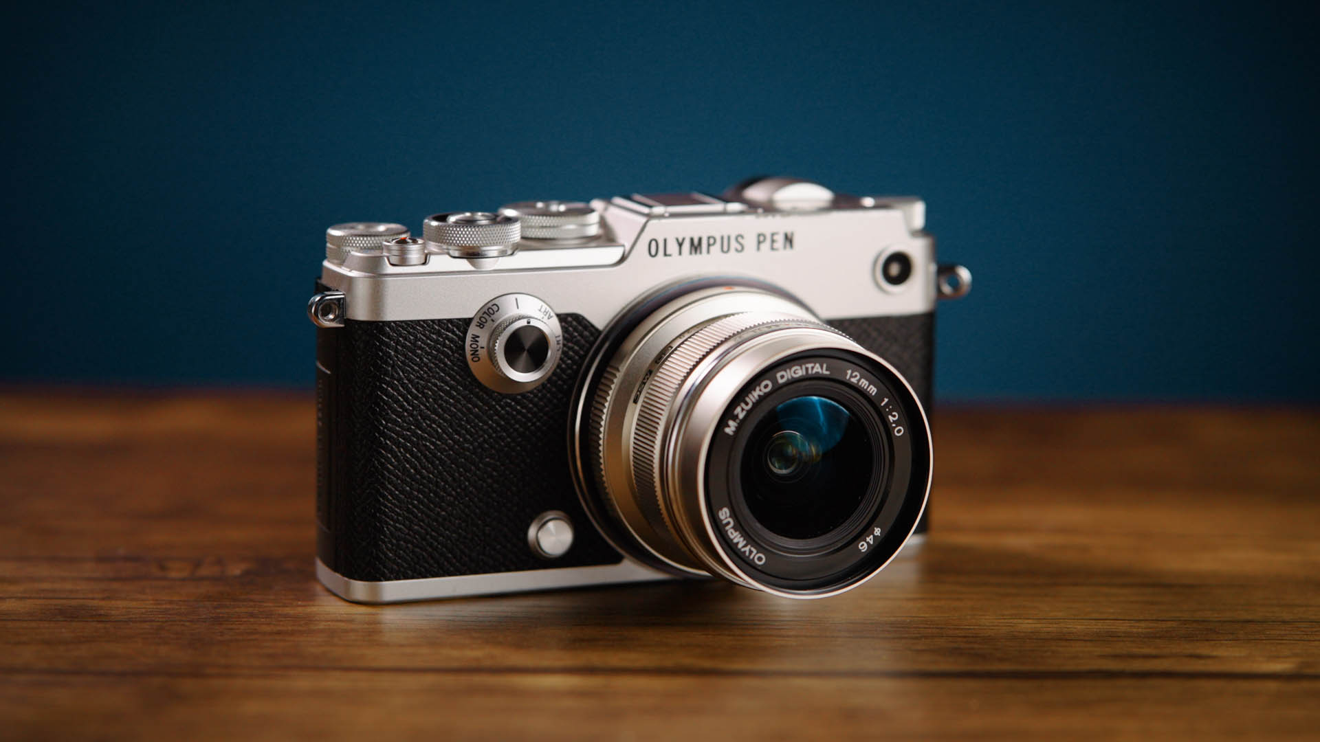 Gebrauchte Olympus PEN-F von MPB auf einem Holztisch