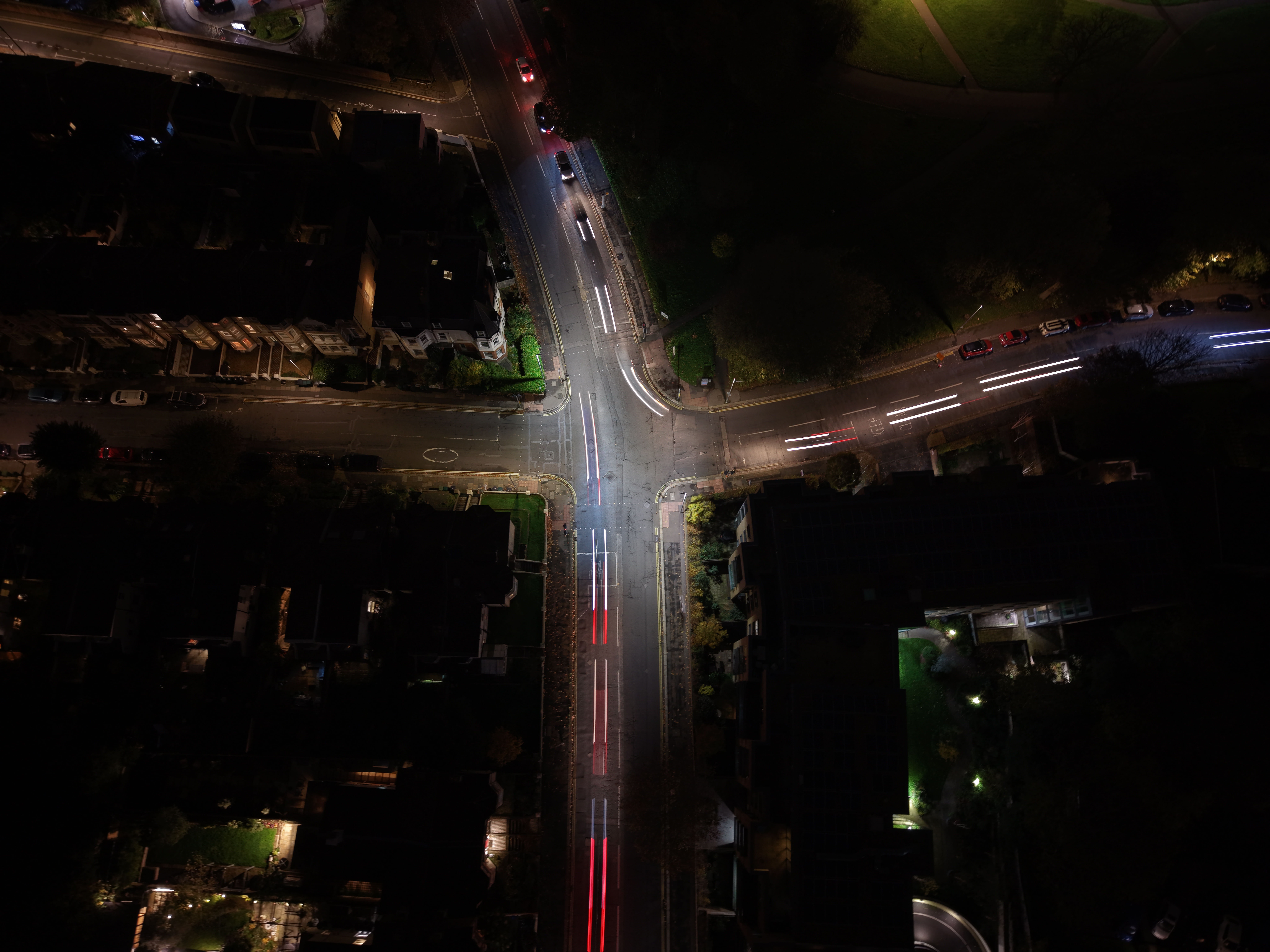 Imagem aérea noturna captada com o DJI Mini 5 Pro, mostrando um cruzamento urbano iluminado por carros em movimento. Os rastos de luz destacam o controlo da exposição e o desempenho do drone em condições de pouca luz.