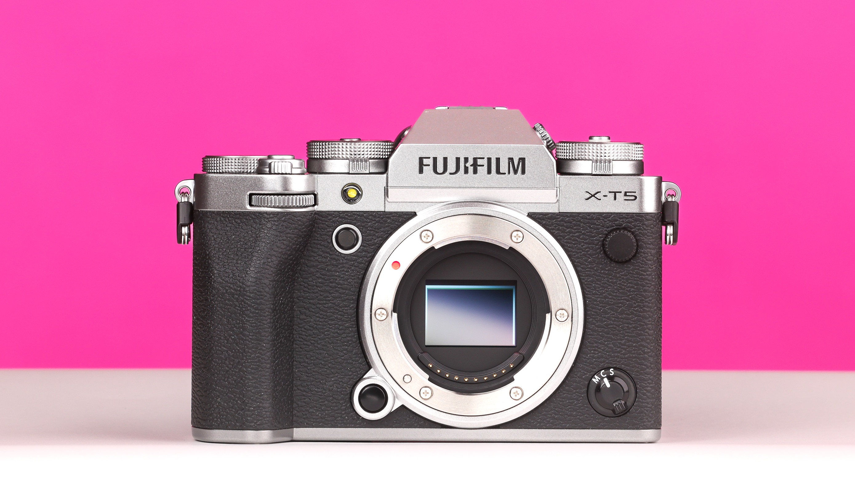 Fujifilm X-T5 on a white and pink background. 
