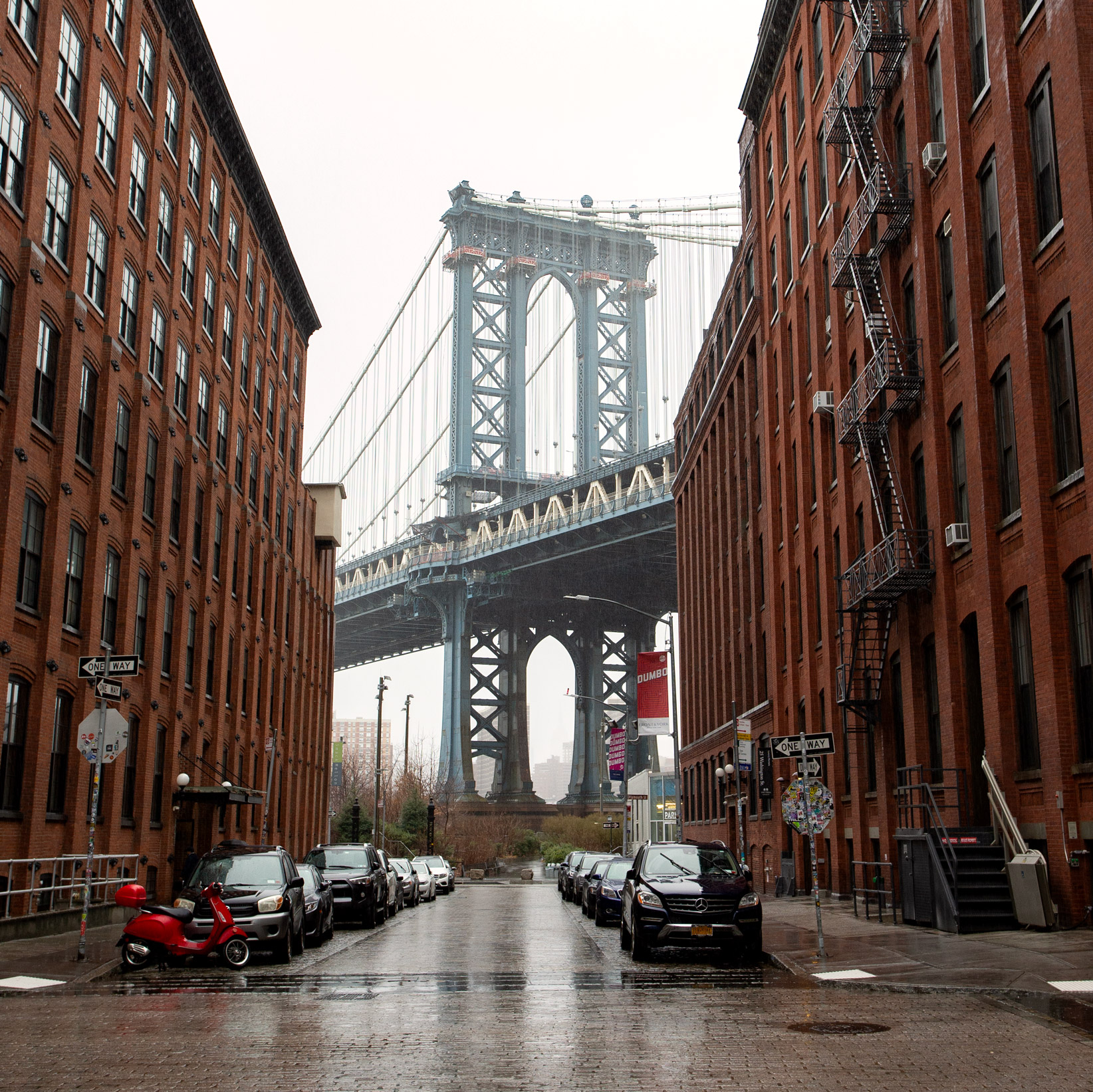 View of Brooklyn street on a rainy day with blue Manhattan Bridge in the background, photo by Kristi Townsend.