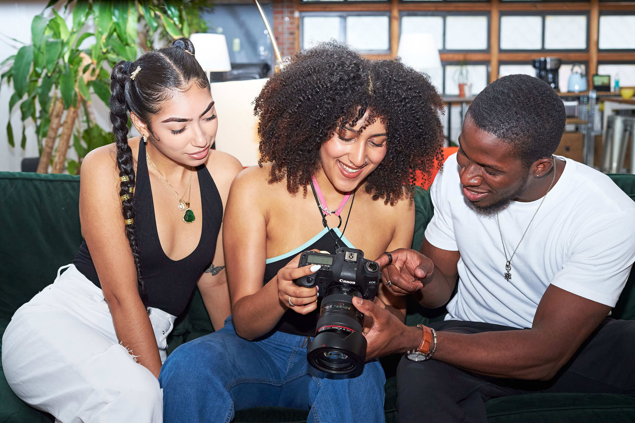 Três estudantes a olhar para uma câmara