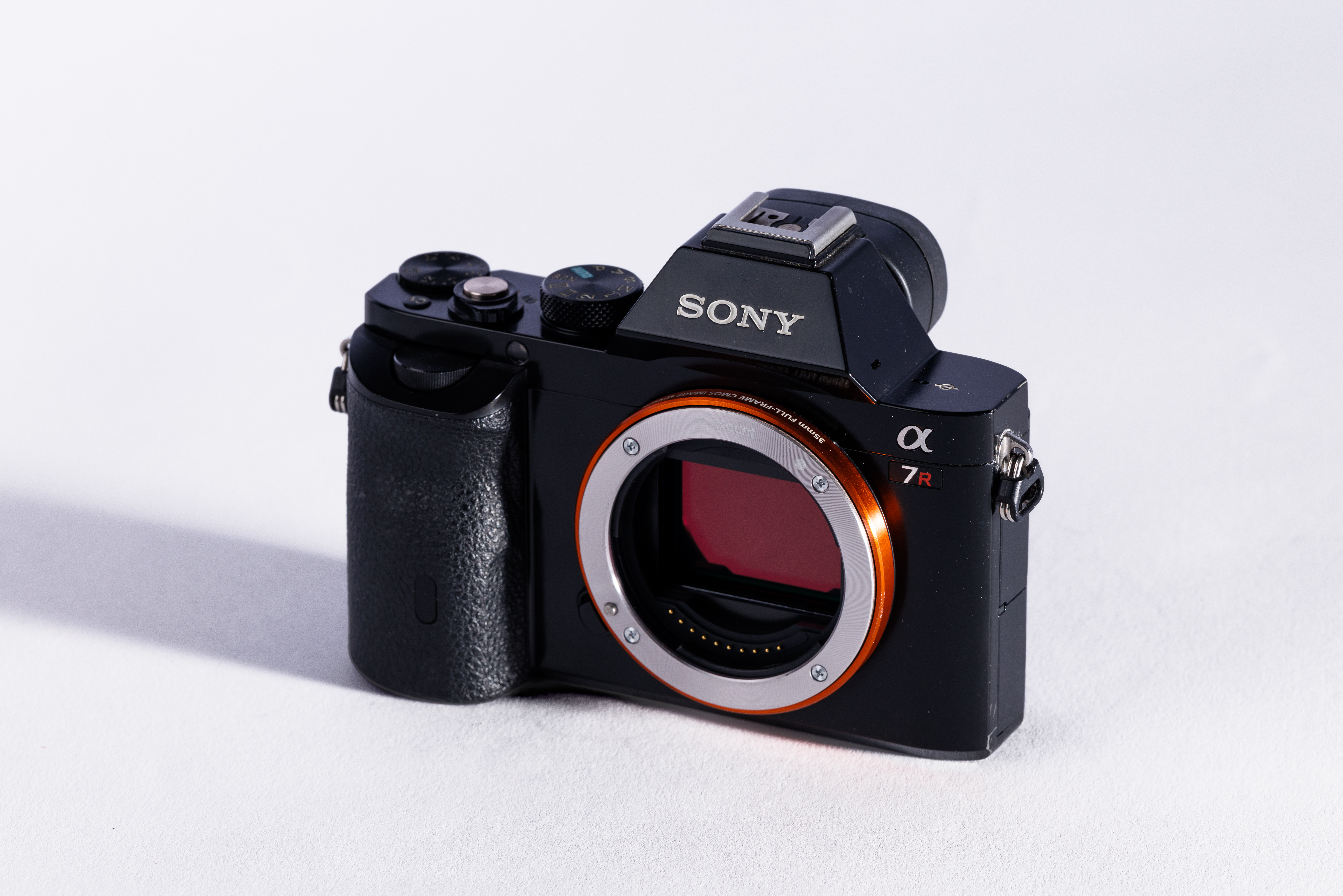 A used Sony A7R body on a white background, with a shadow to the left. 