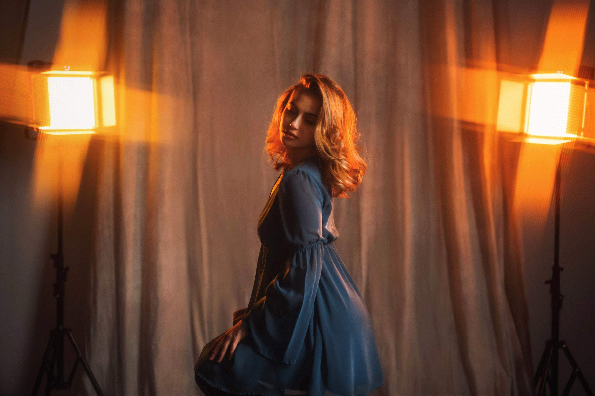 Person posing with two lights shining in background, photo by Brandon Woelfel