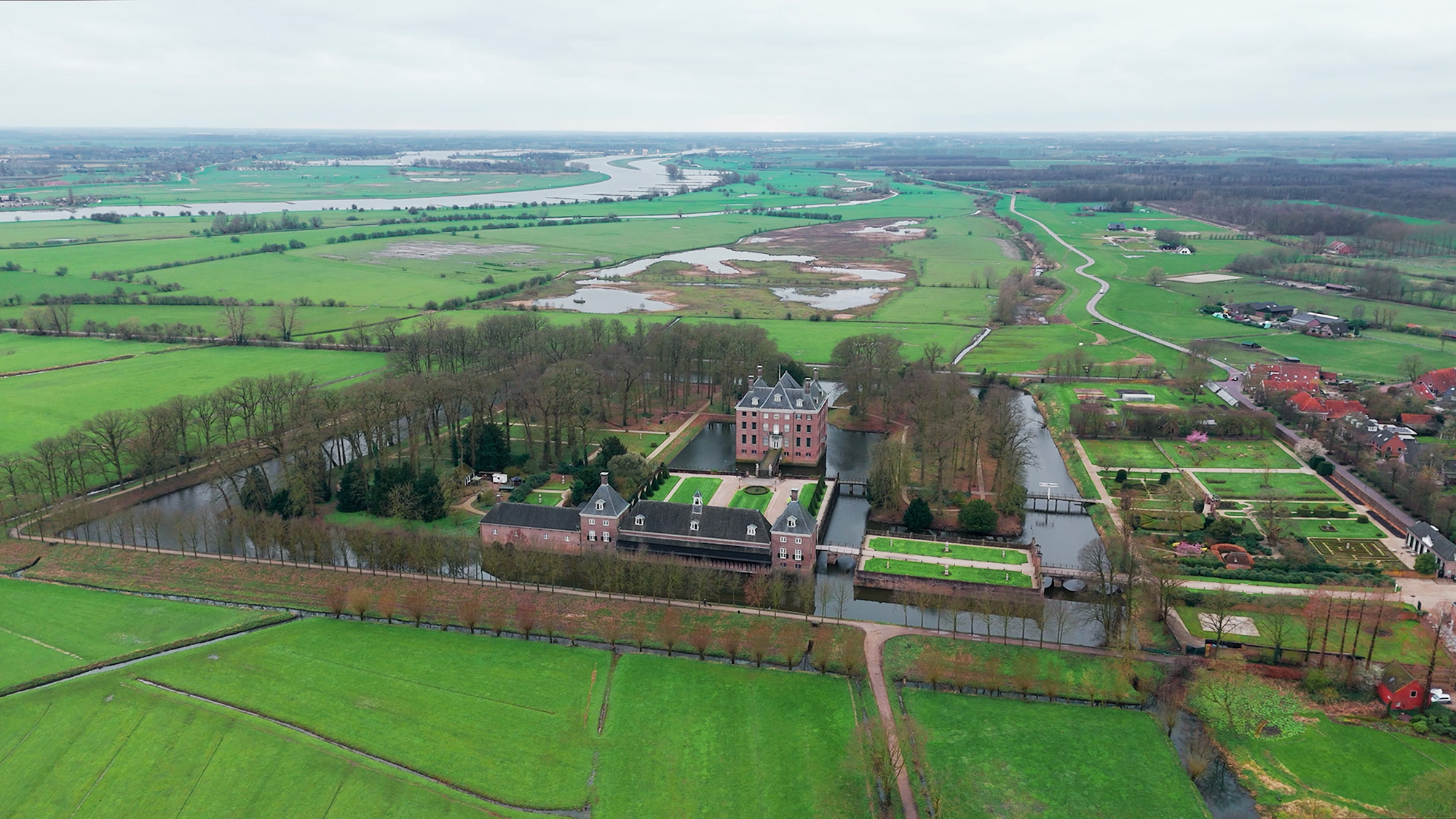 An impressive aerial view of a historic castle surrounded by vast green fields, canals and carefully landscaped gardens. Perfect for lovers of nature and architecture, shot with the DJI at 24mm.