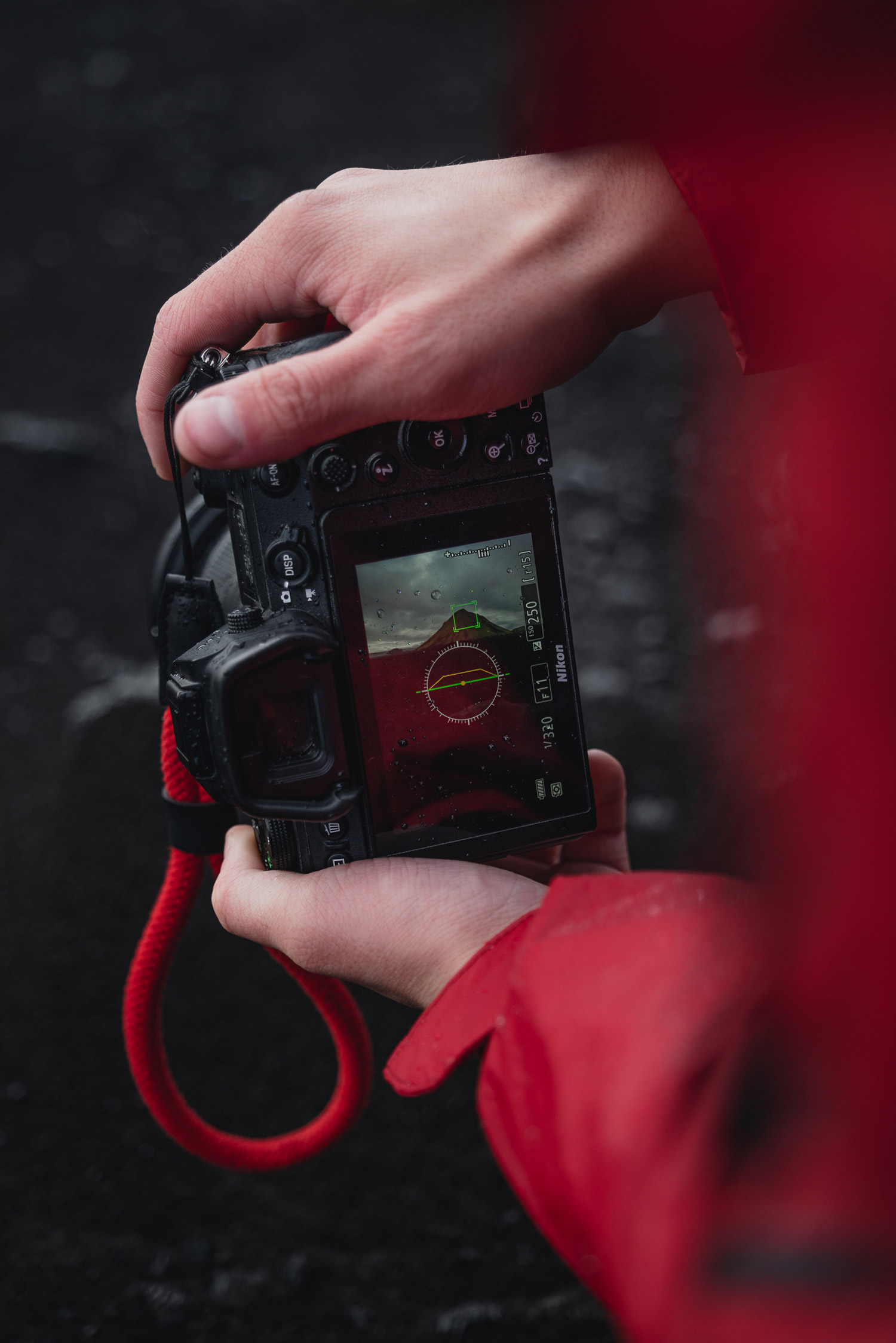 A close-up photo of the hands of Paul Watson, wearing a red shirt, shooting with the Nikon Z6 in Iceland, picture taken with a Panasonic S1R