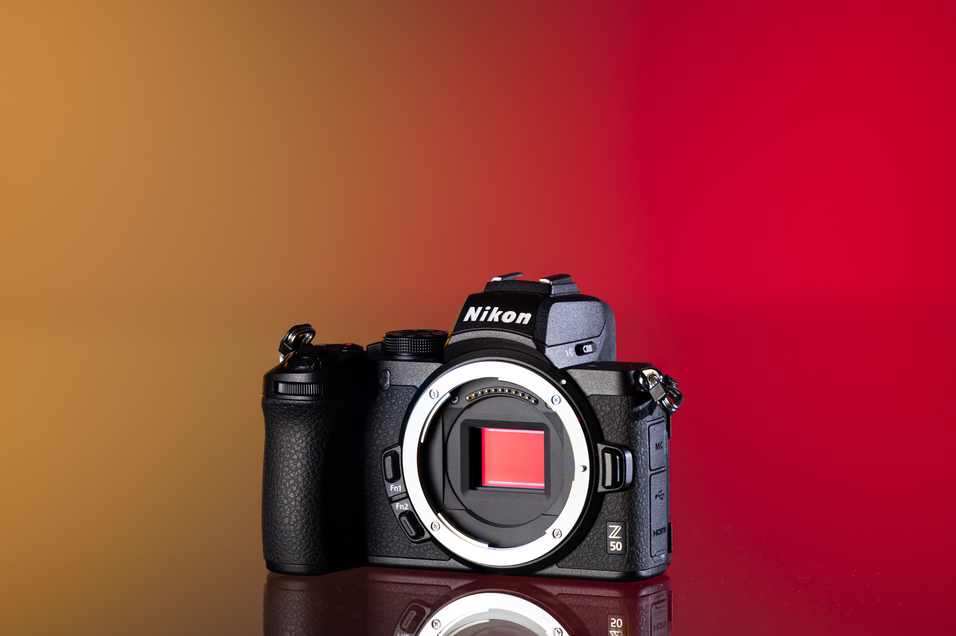 Cámara Nikon Z50 de segunda mano sobre un fondo amarillo y rojo