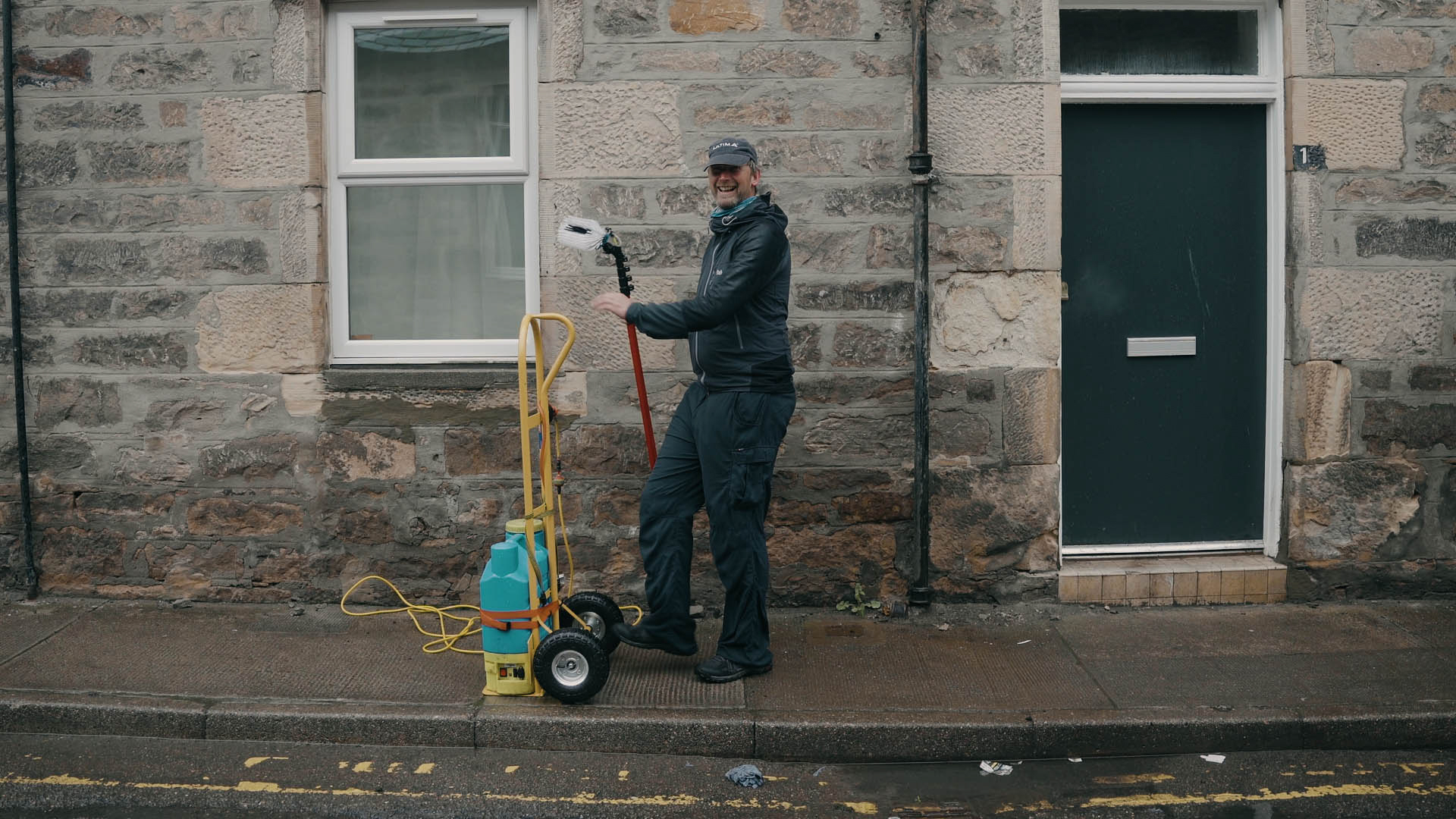 Steve Truluck maakt de ramen van een stenen huis in Schotland schoon, een opname uit de korte film Truluck van Matt Cannon en Jake Smallwood.