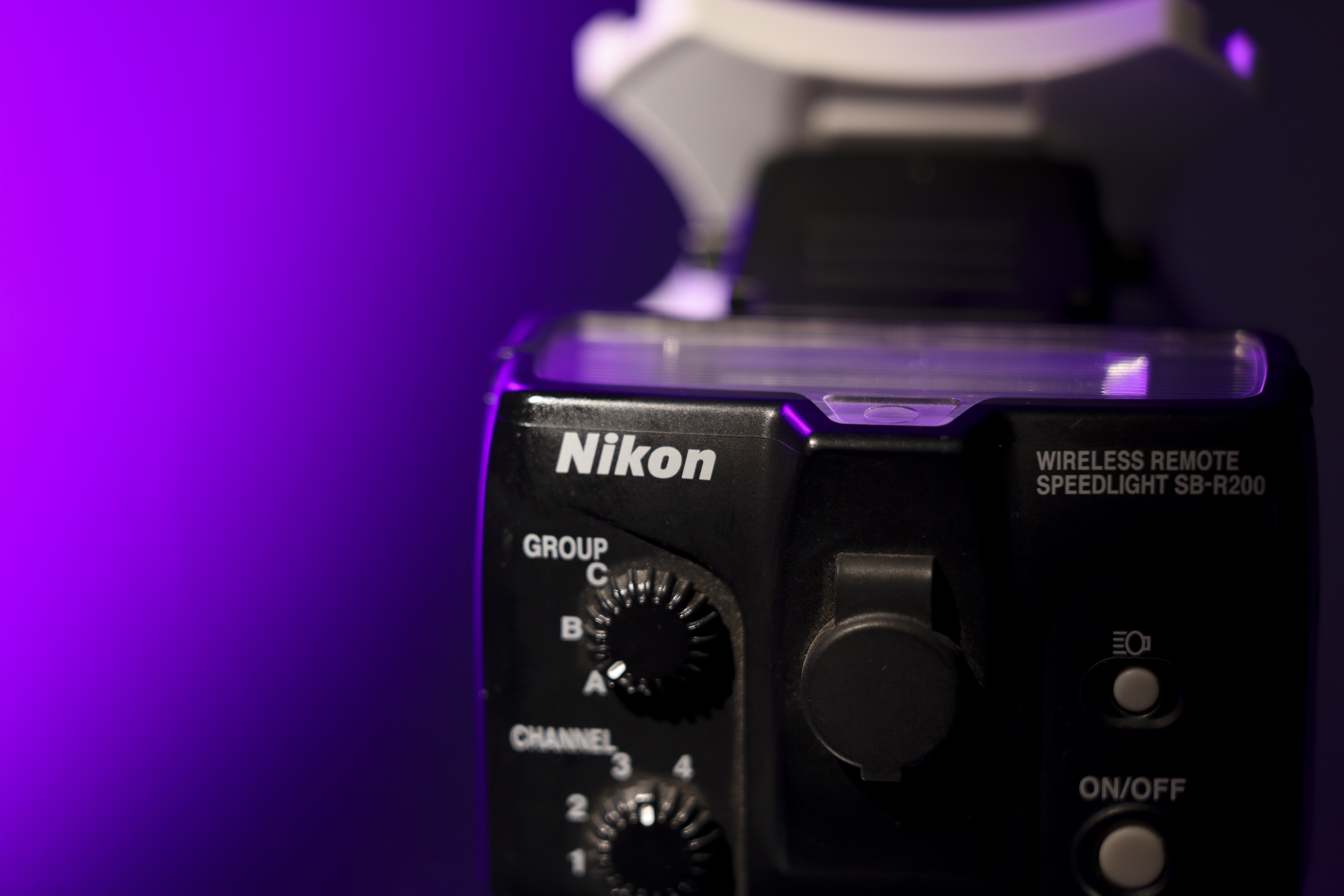 Nikon SB-R200 Speedlight against a purple background.