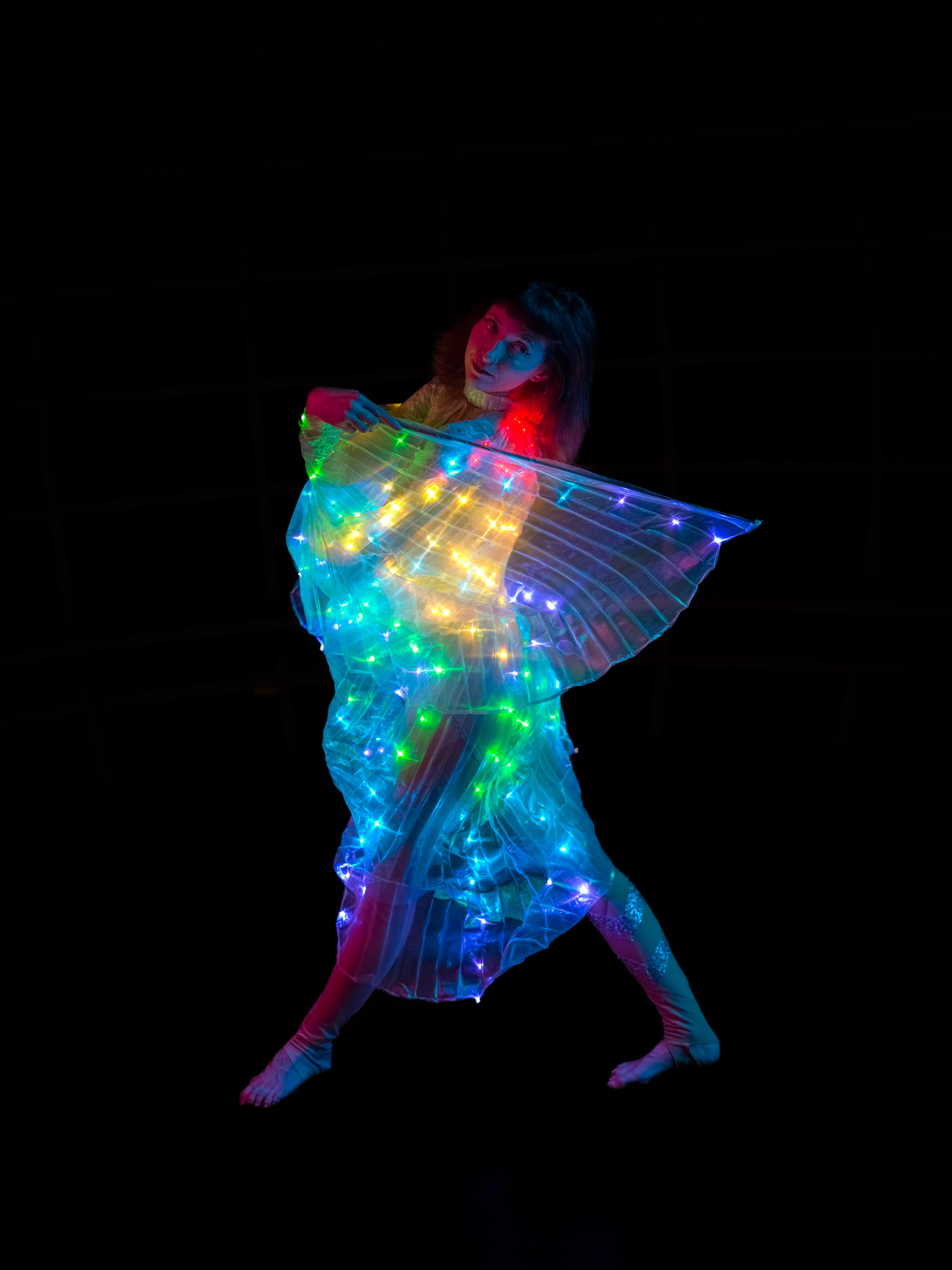 Ganzkörperporträt einer Tänzerin in Neonlicht vor schwarzem Hintergrund, aufgenommen von Ian Howorth mit einer Hasselblad X2D 100C