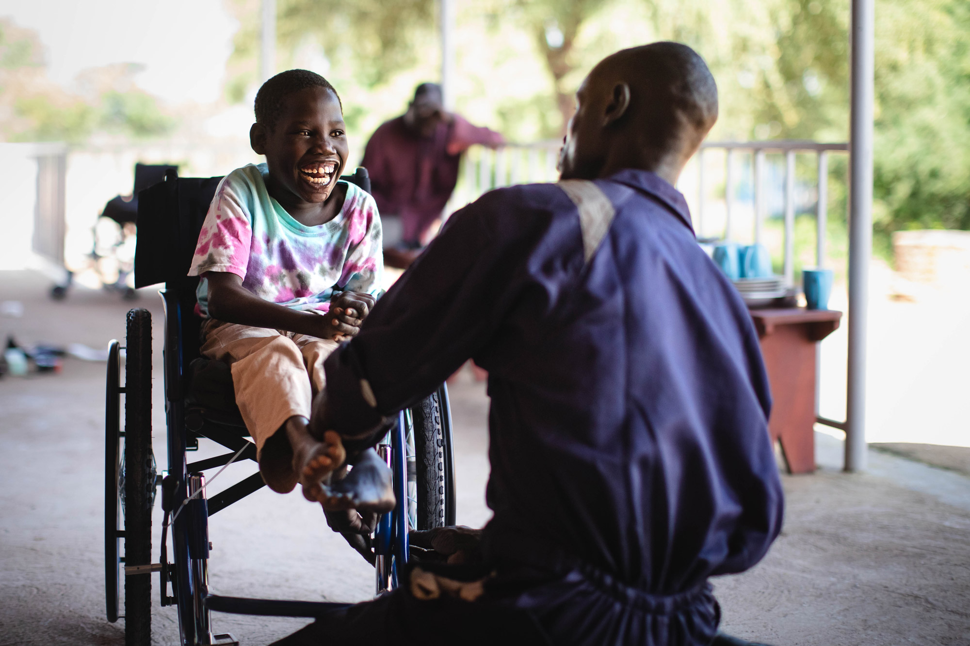 Un membre du personnel de l'action sanitaire Hope avec un jeune au centre de réhabilitation New Hope Bidibidi en Ouganda, photo prise par Thomas Williams avec un Canon EOS 5D Mark IV.