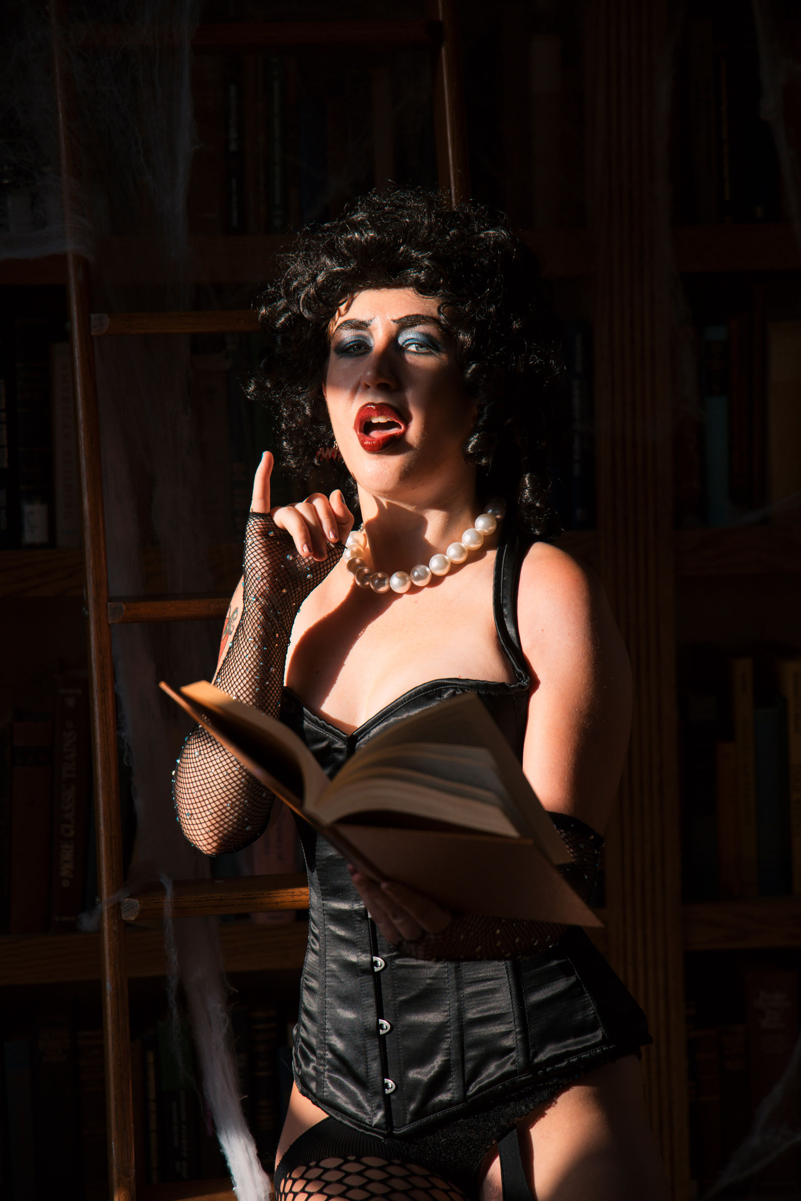 Burlesque cosplayer poses with a book.