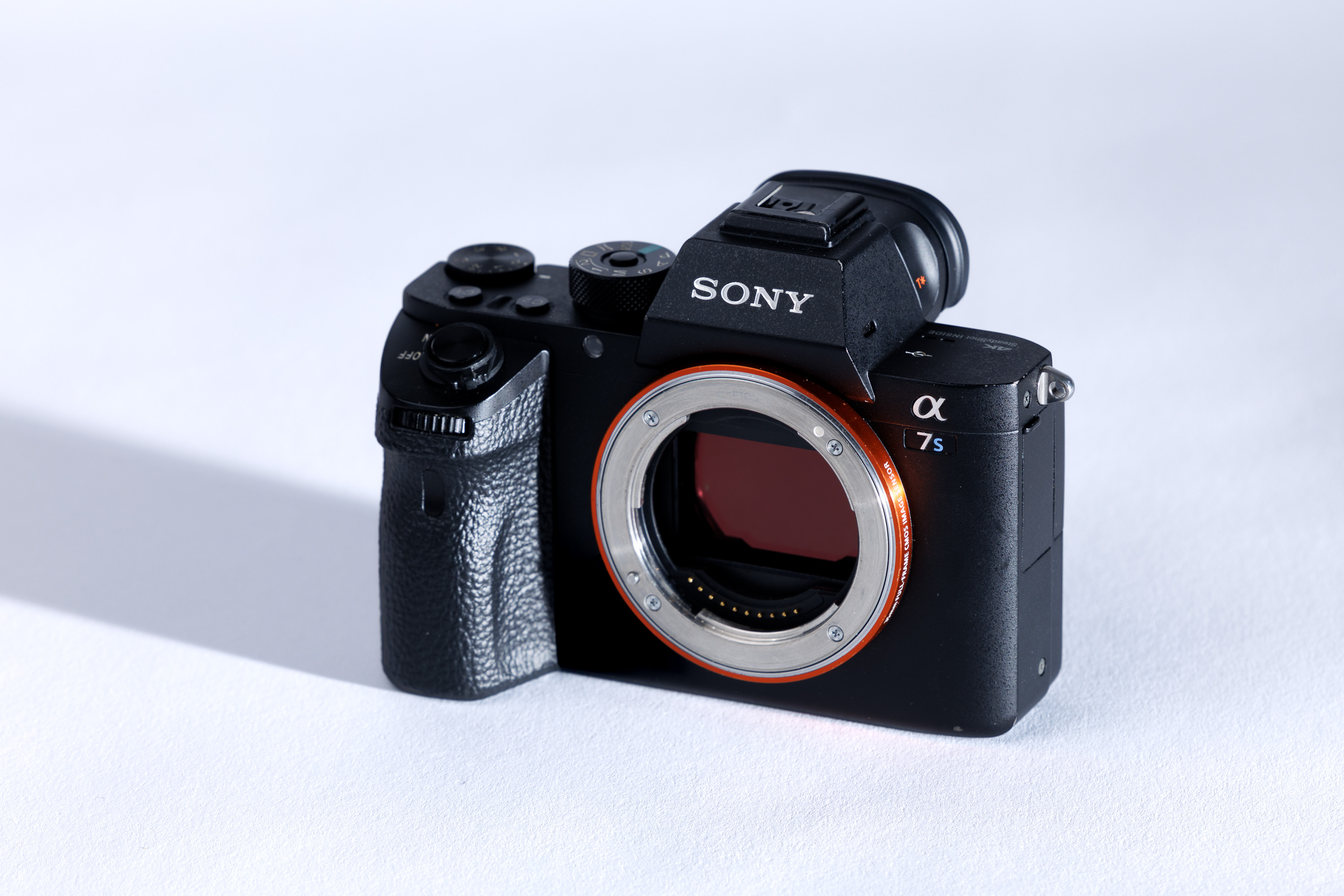 A used Sony A7S II body on a white background, with a shadow to the left. 