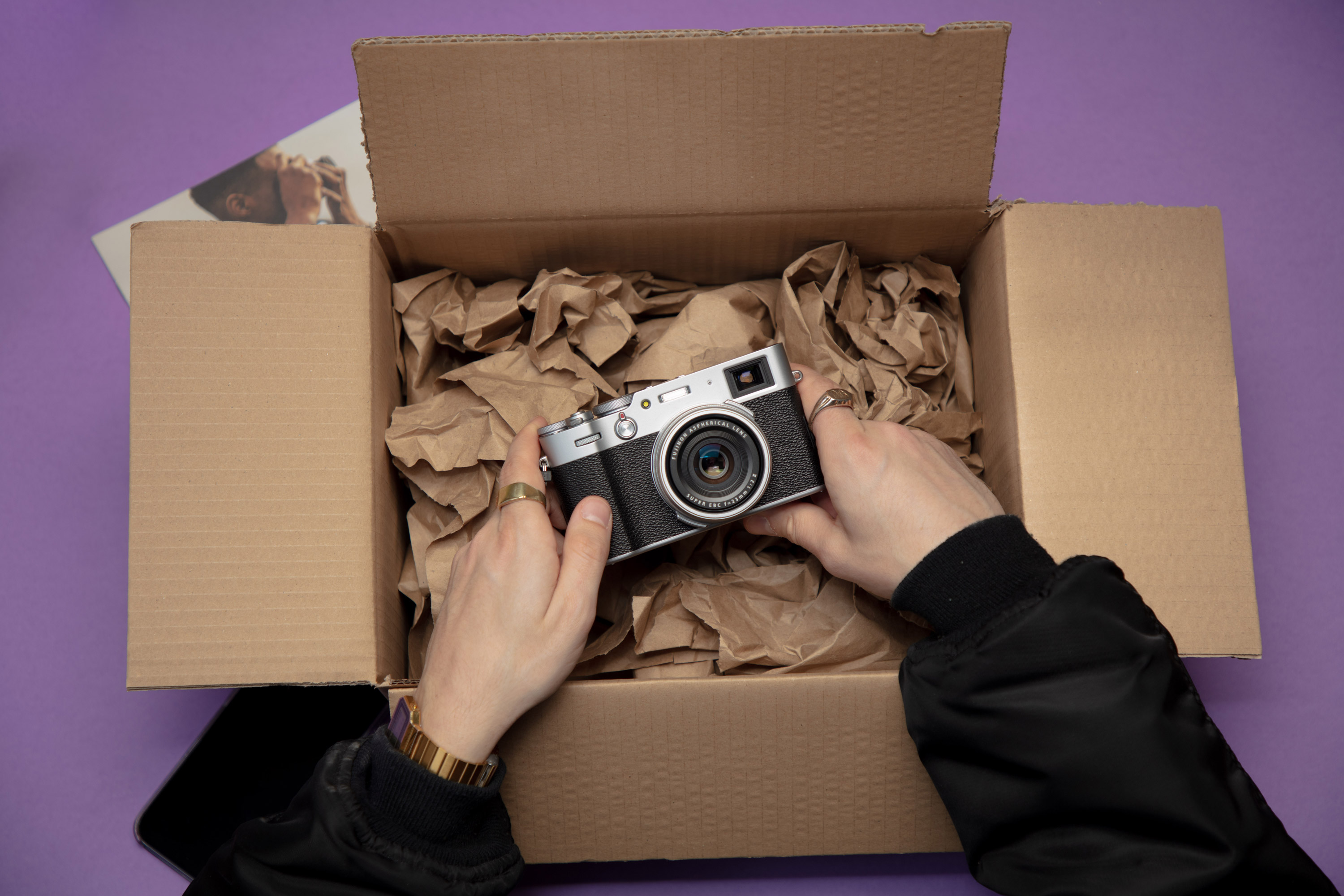 Handen die een Fujifilm camera uit de doos halen