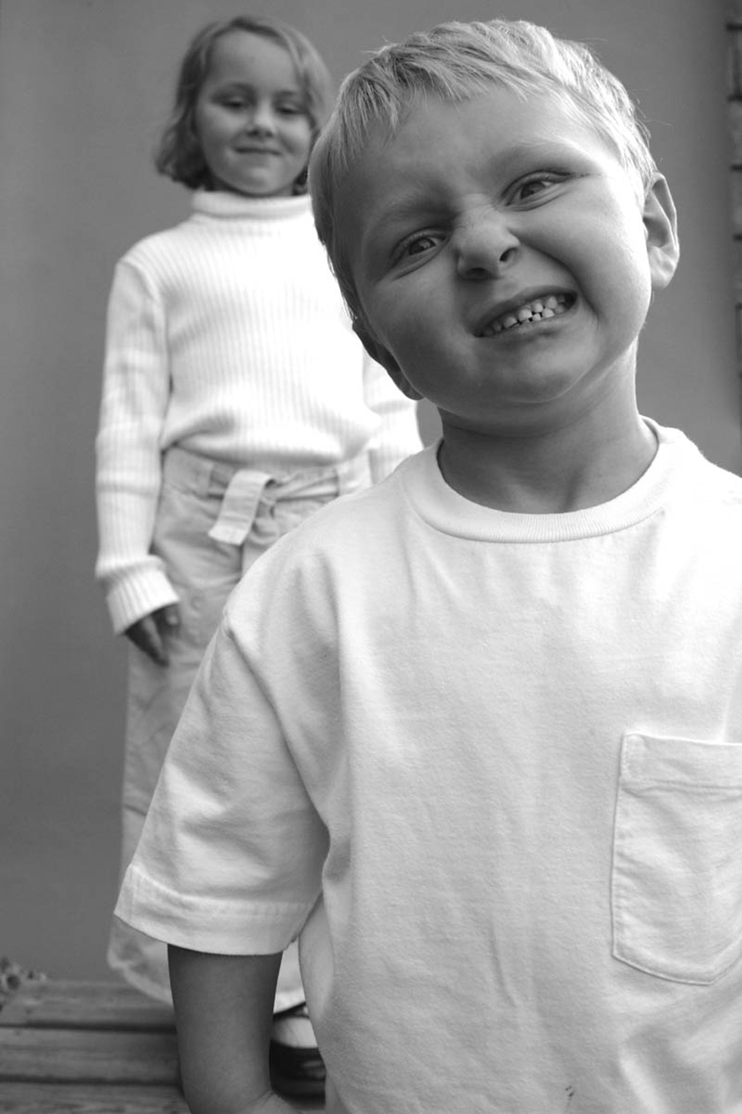 A black and white image of two children dressed in white. Shot by Kim Fuller.
